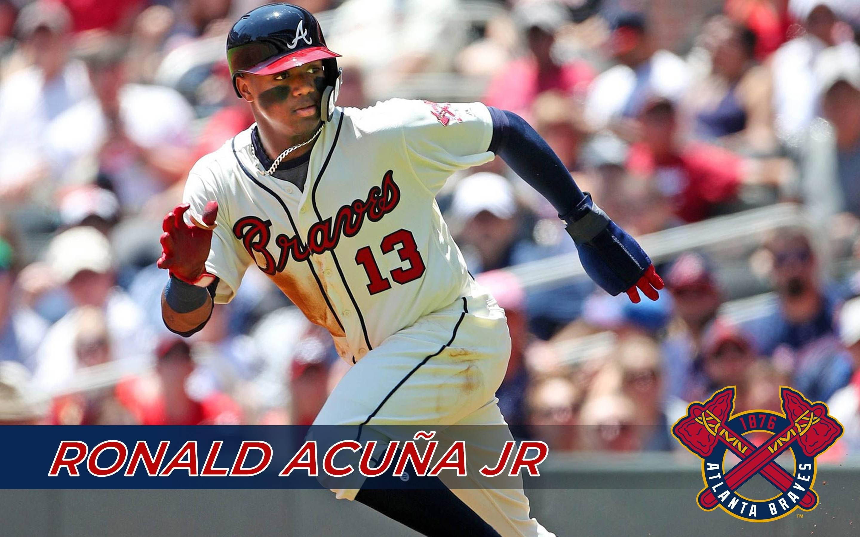 Acuna 桌布 壁紙 — 棒球選手 Ronald Acuña Jr. 身穿亞特蘭大勇士隊球衣，在陽光明媚的比賽中衝刺，背景是模糊的球迷。