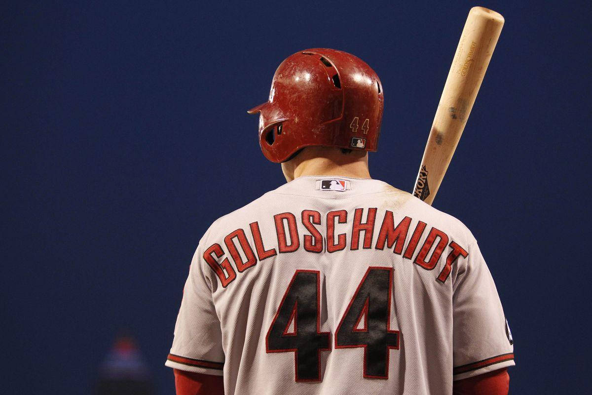 Paul Goldschmidt 桌布 壁紙 — 棒球選手Goldschmidt身穿44號球衣，手持球棒，背對深藍色背景的背面視圖。