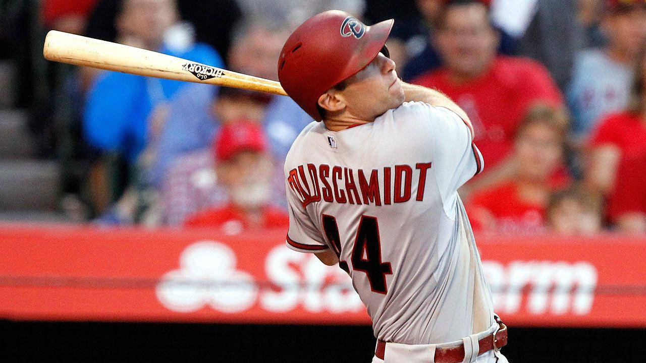 Paul Goldschmidt 桌布 壁紙 — 棒球選手Mike Trout戴紅色頭盔、穿白色球衣，在球場中揮棒，背景是模糊的人群。