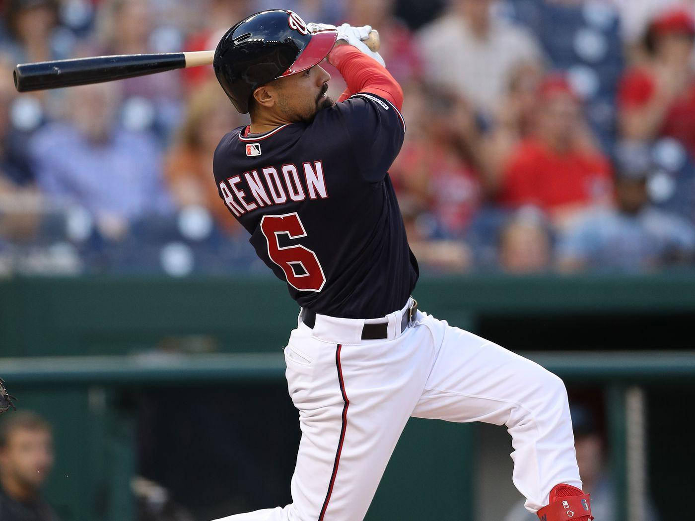 anthony rendon 桌布 壁紙 — 棒球選手Rendon身穿海軍藍球衣，背號6，在日間比賽中揮棒，背景是模糊的人群。