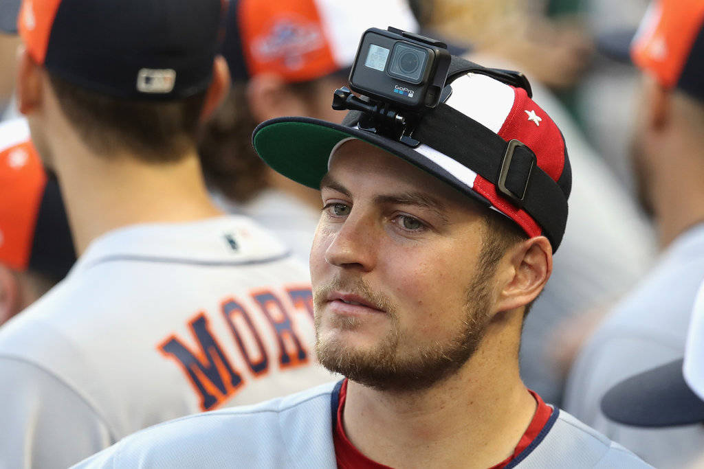 Bauer 桌布 壁紙 — 棒球選手在帽子上安裝了GoPro，比賽期間若有所思地凝視，背景有隊友。