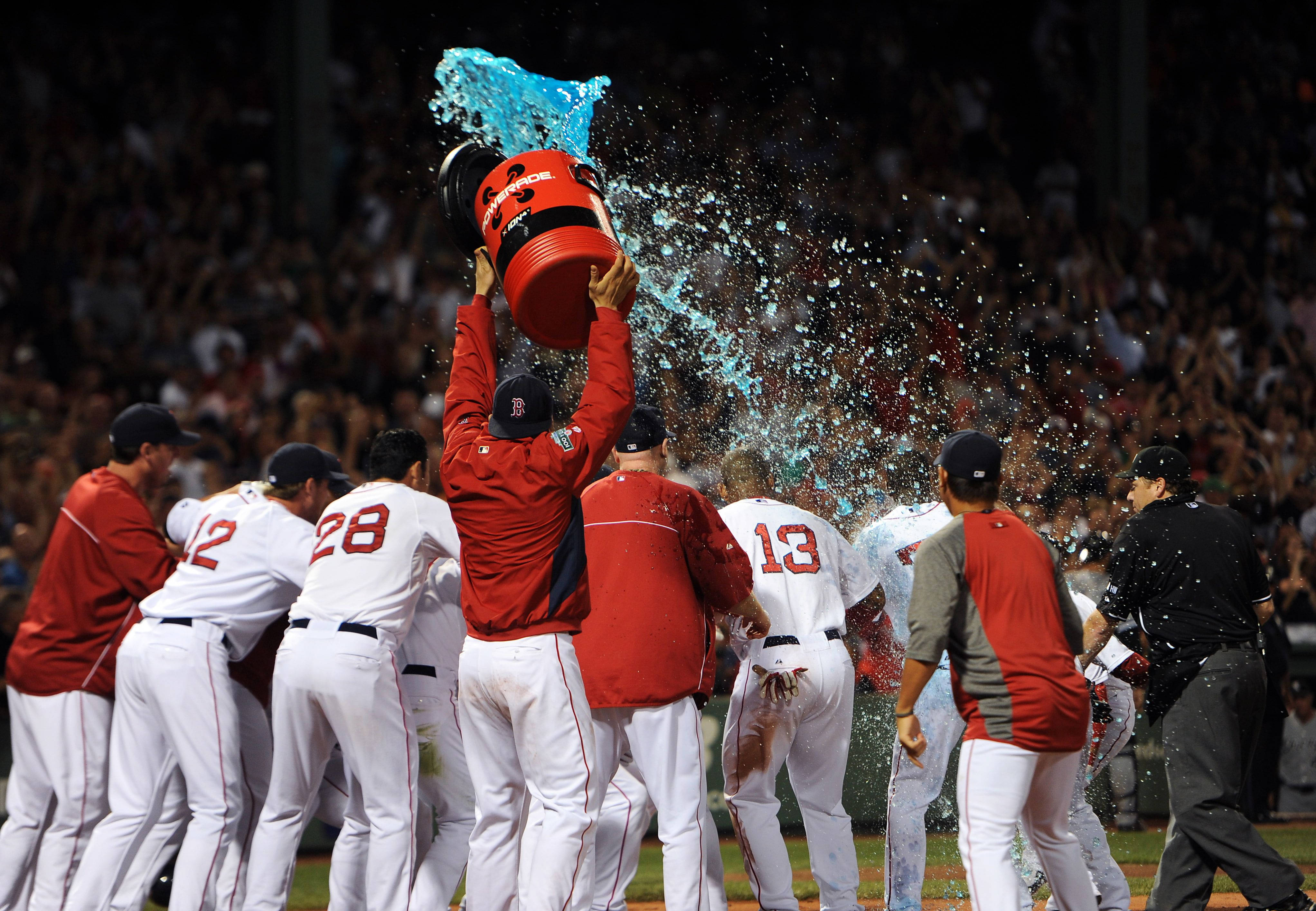 Boston Red Sox 桌布 壁紙 — 棒球選手慶祝勝利，其中一人將冰冷的藍色水倒在陽光下的隊友身上。