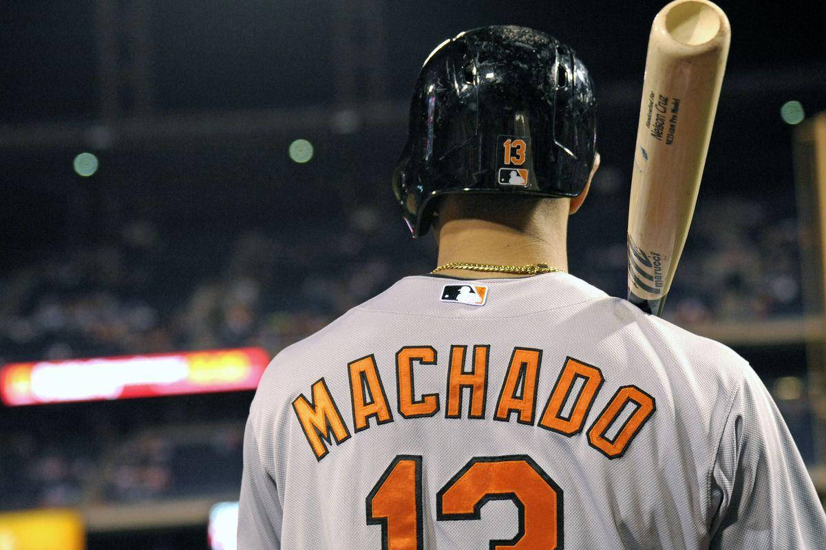 Machado 桌布 壁紙 — 棒球選手曼尼·馬查多戴頭盔穿13號球衣，在夜間比賽中手持球棒的背面視角。