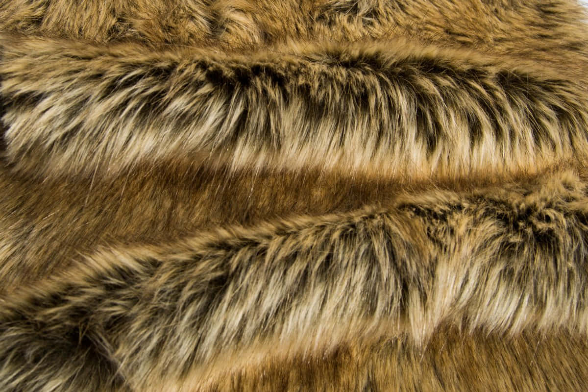 Animal Fur 桌布 壁紙 — 棕色和黑色仿皮草的近距離特寫，質感豐富，柔軟的毛絲在輕柔的褶皺中捕捉光線。