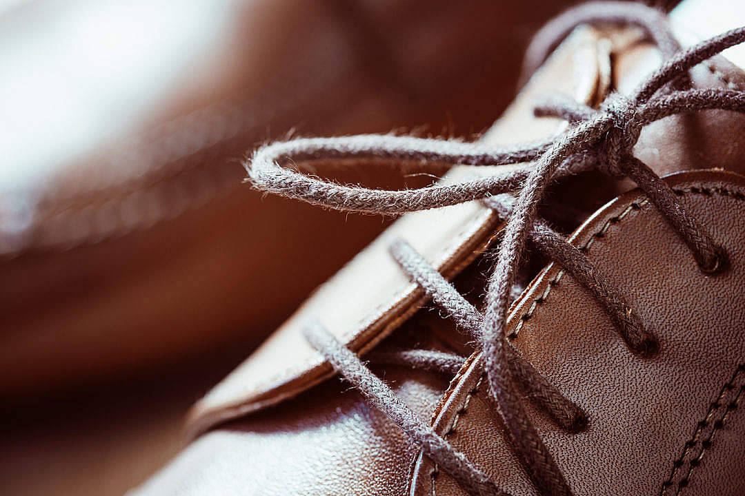 Shoe 桌布 壁紙 — 棕色皮鞋特寫，鞋帶磨損，縫線清晰可見，在溫暖燈光下。