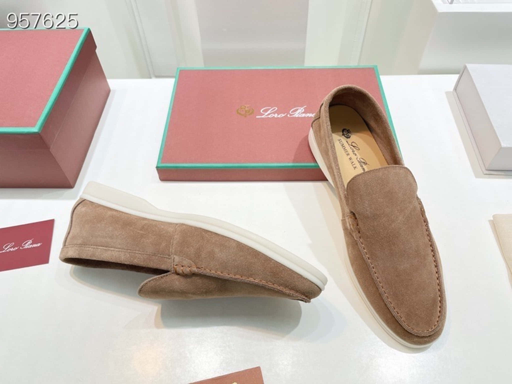 鞋子 桌布 壁紙 — 棕色麂皮樂福鞋搭配白色鞋底，展示在白色表面上，旁邊有品牌粉紅色盒子。