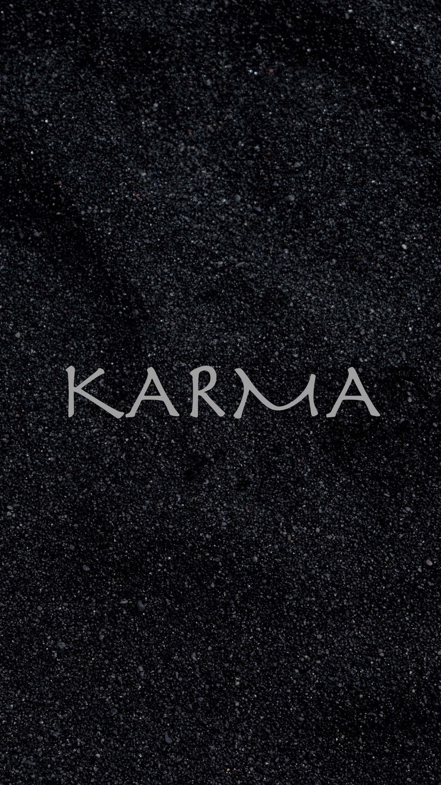karma 桌布 壁紙 — 「業力」一詞在帶有閃爍顆粒的紋理黑色背景上閃耀著銀色光芒。