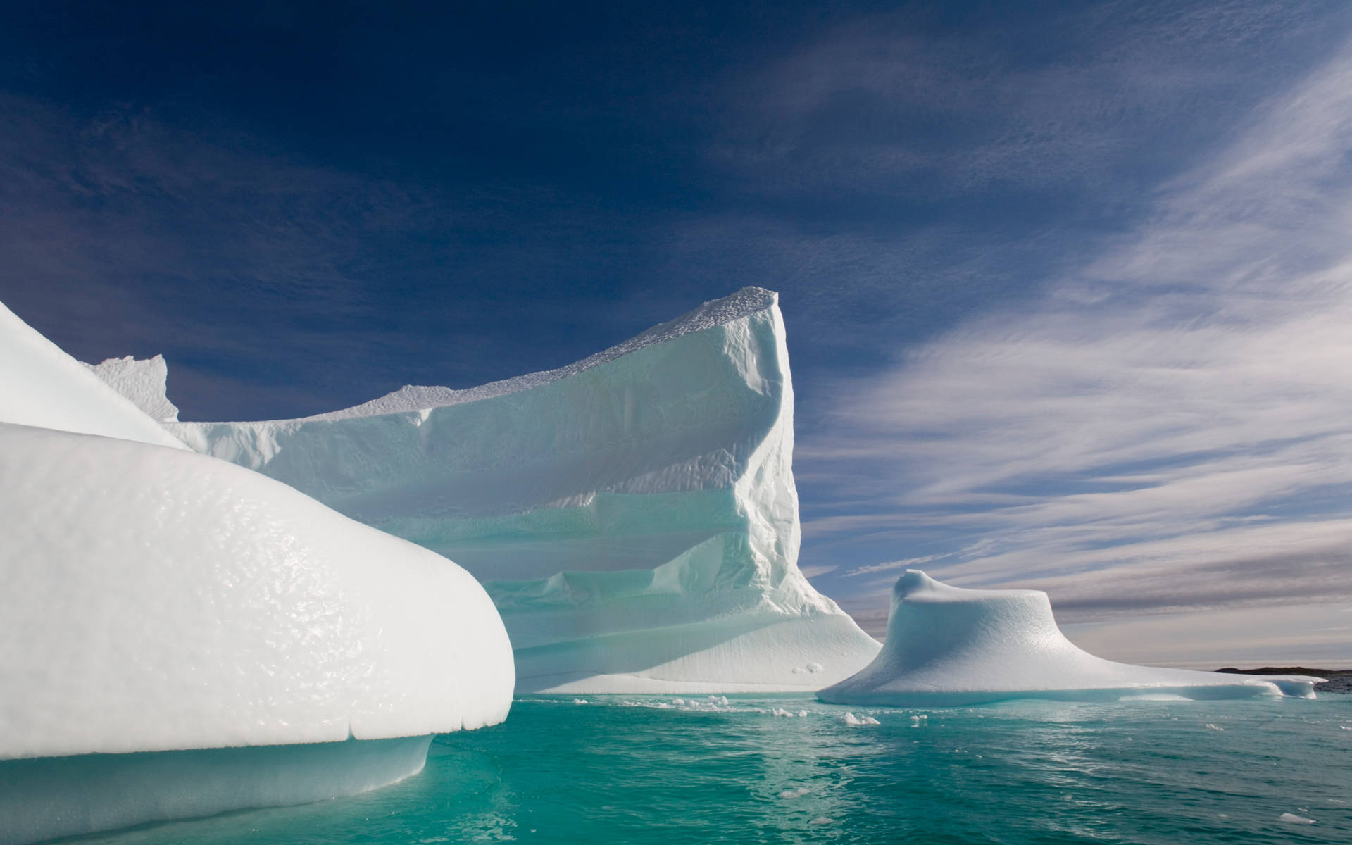 Greenland 桌布 壁紙 — 極地荒野中巨大的冰山，伴隨著碧綠色的海水和深藍色的天空。