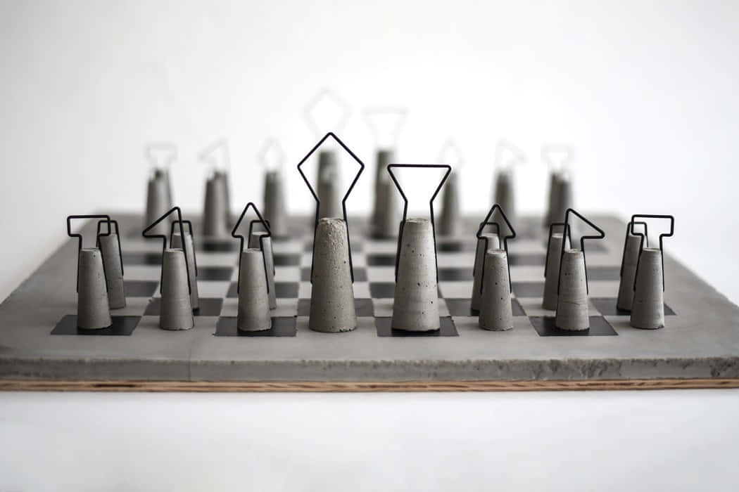 Gray Aesthetic 桌布 壁紙 — 極簡主義混凝土國際象棋套裝，線框棋子排列在棋盤上，背景為 stark 白色。