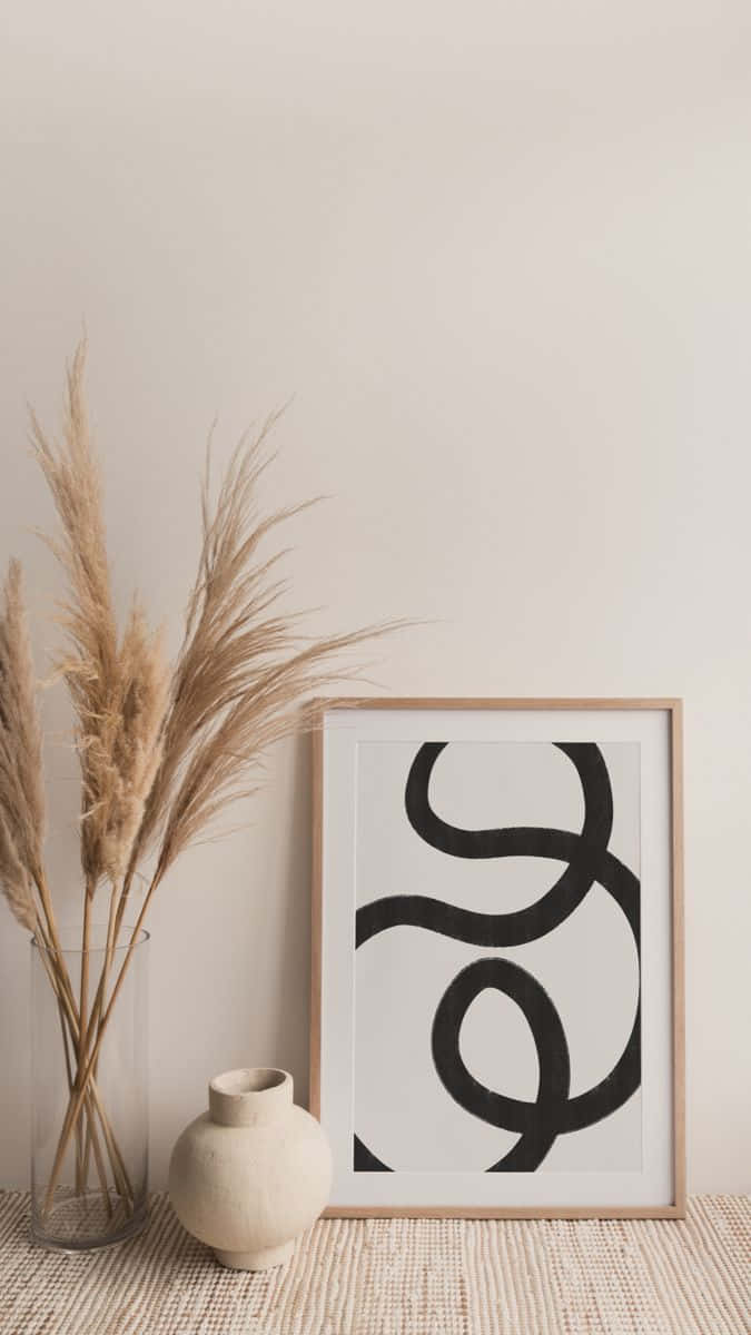 Modern Minimalist Art 桌布 壁紙 — 極簡室內場景，編織地毯上擺放著乾燥蒲葦、陶瓷花瓶，旁邊是裱框的抽象黑色線條藝術品。