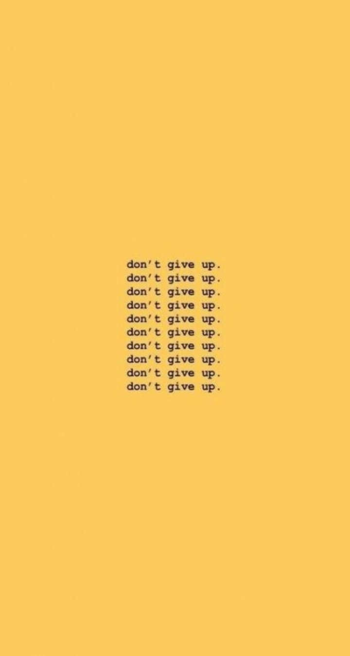桌布 壁紙 — 極簡激勵文字，以黑色小寫字母重複 'don't give up'，居中於純芥末黃色背景上。