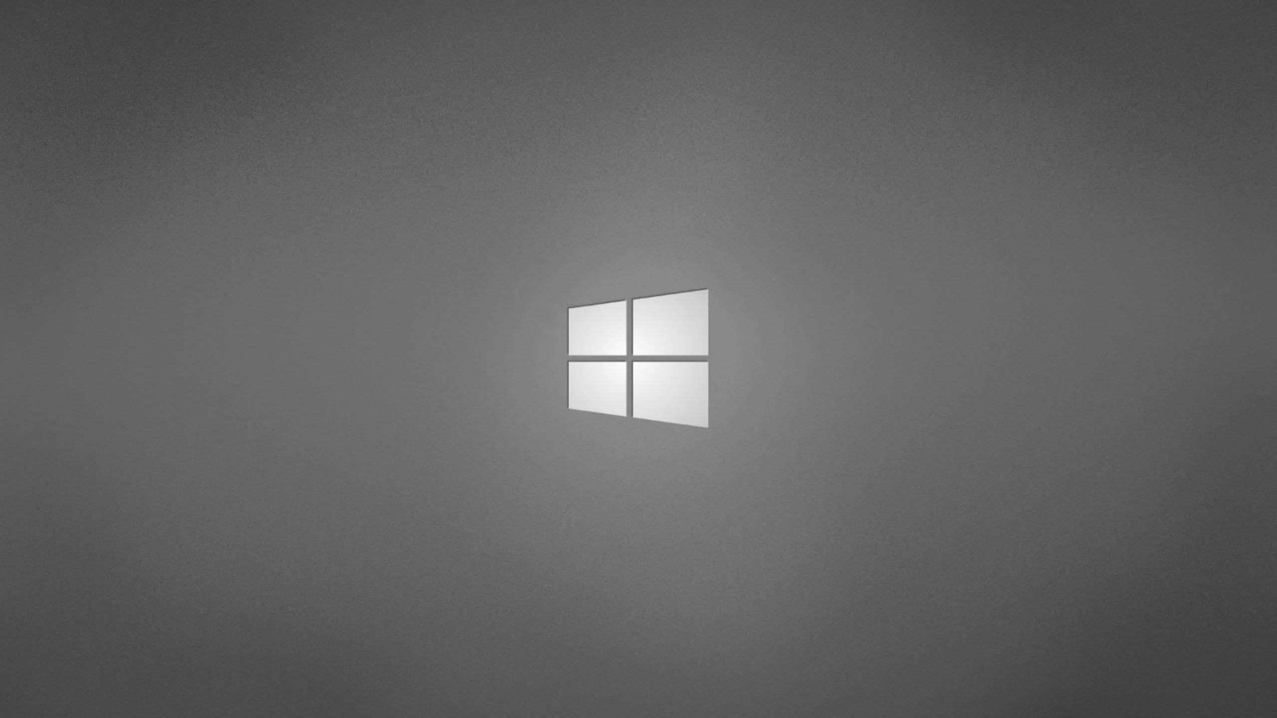 標誌 桌布 壁紙 — 極簡灰色漸變背景，中央有一個發光的白色Windows標誌。