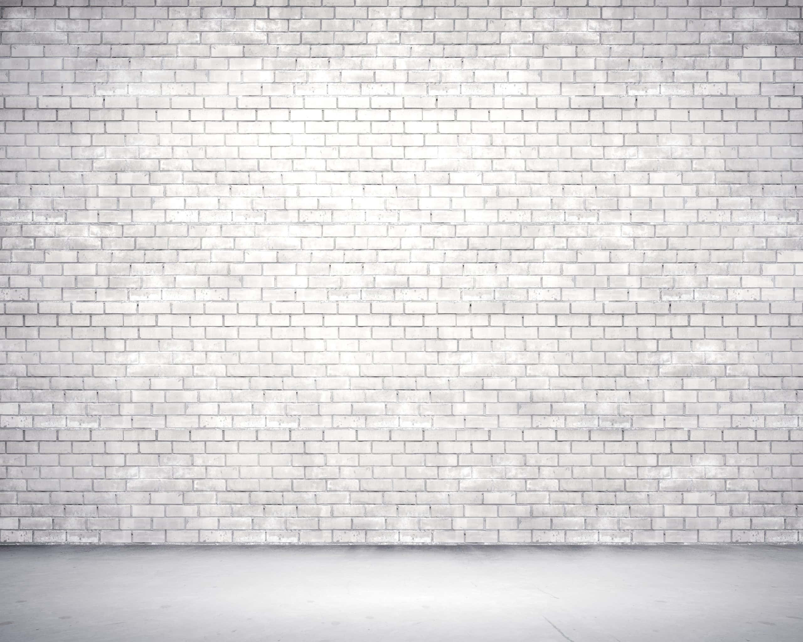 White Brick Wall 桌布 壁紙 — 極簡白色磚牆，帶有細微紋理和柔和光線，營造出乾淨的城市背景。
