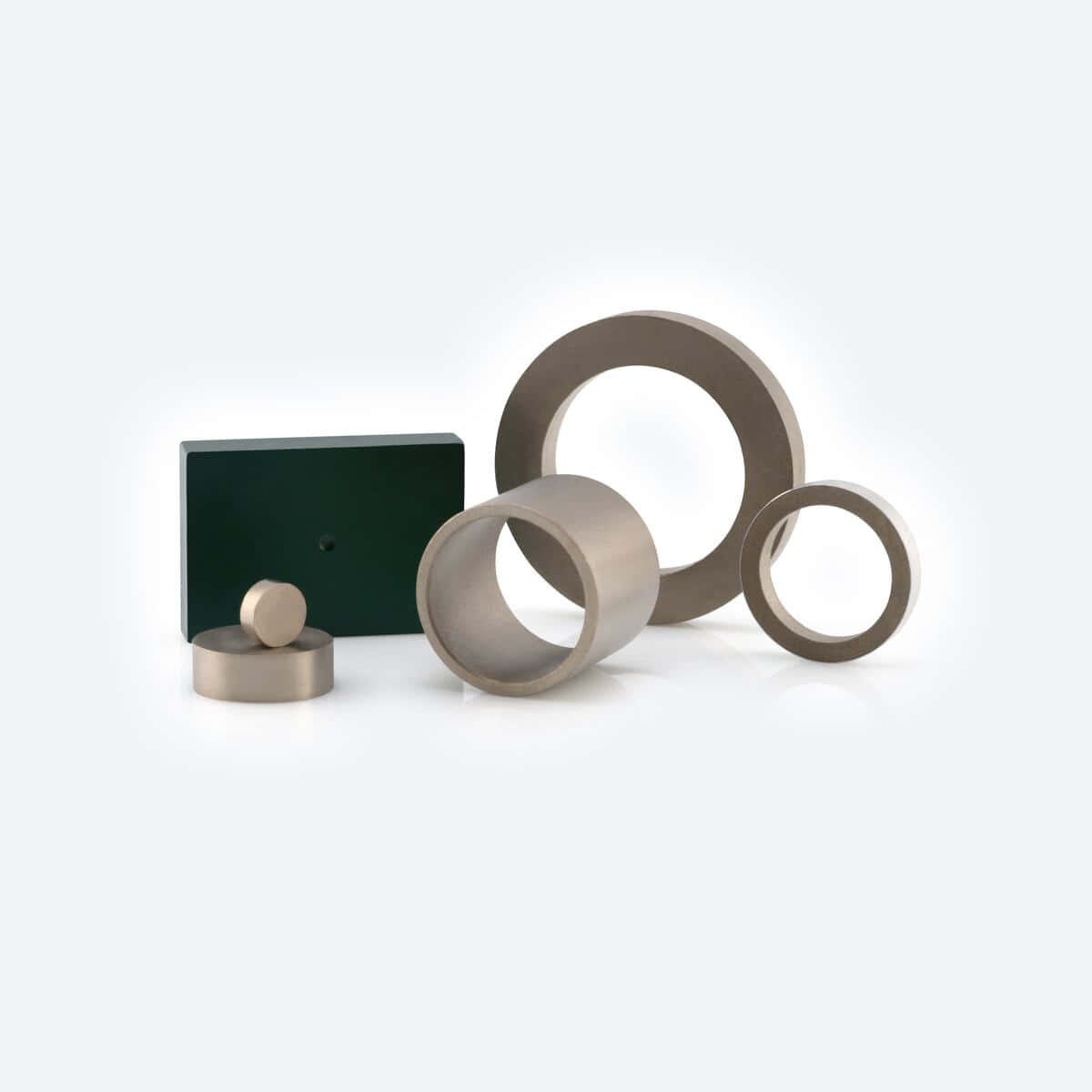 Material 桌布 壁紙 — 極簡風格工作室拍攝，金屬幾何形狀包括圓環、圓柱體和一個深綠色方塊，置於亮白色表面上。