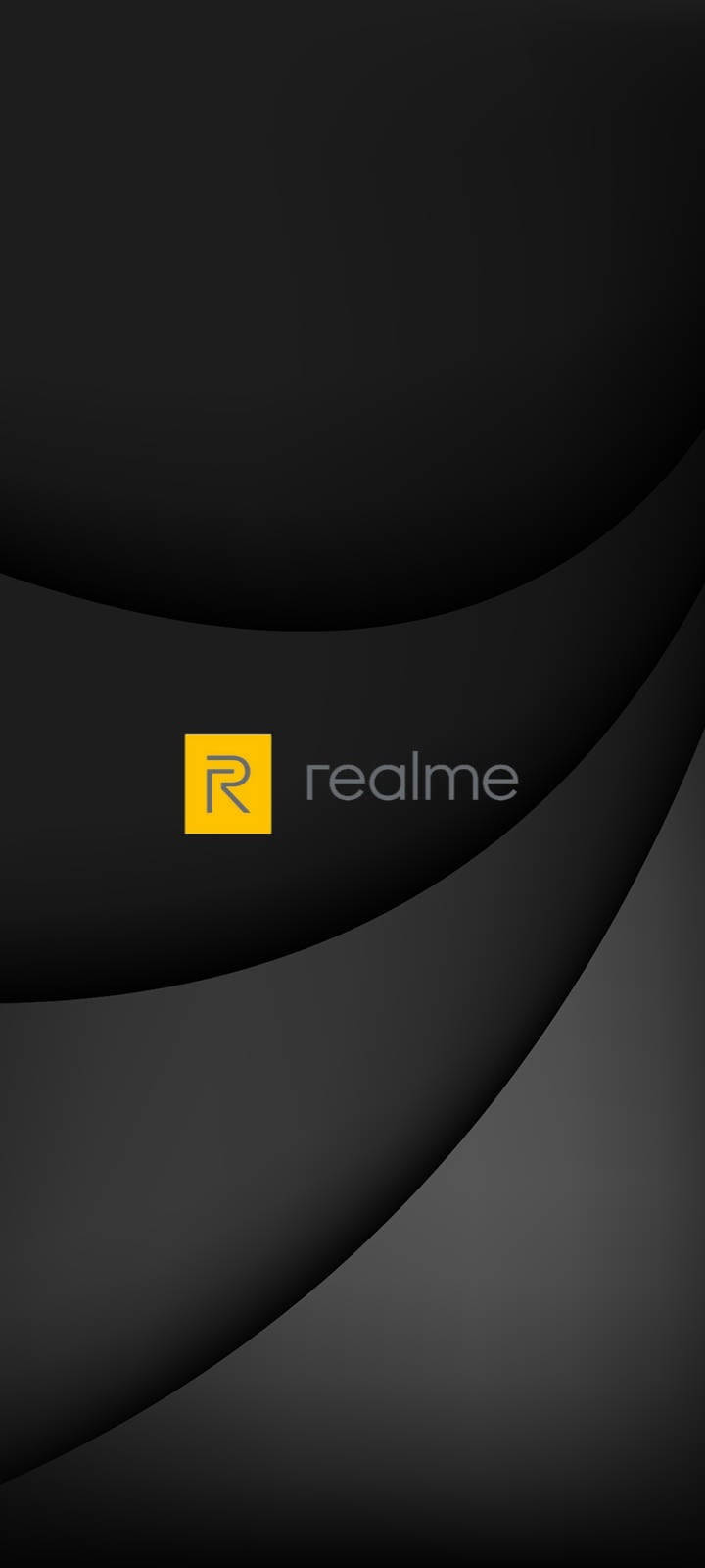  壁紙 — 極簡黑灰色弧形壁紙，中央帶有黃色 realme 標誌和柔和漸變燈光。