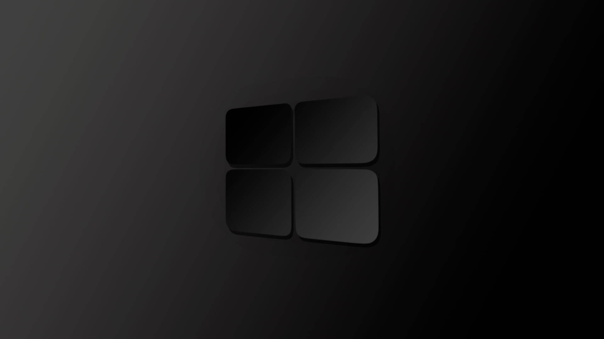 黑色 Windows 10 桌布 壁紙 — 極簡黑色Microsoft標誌，帶有細微漸變和陰影，置於深色漸變背景上。