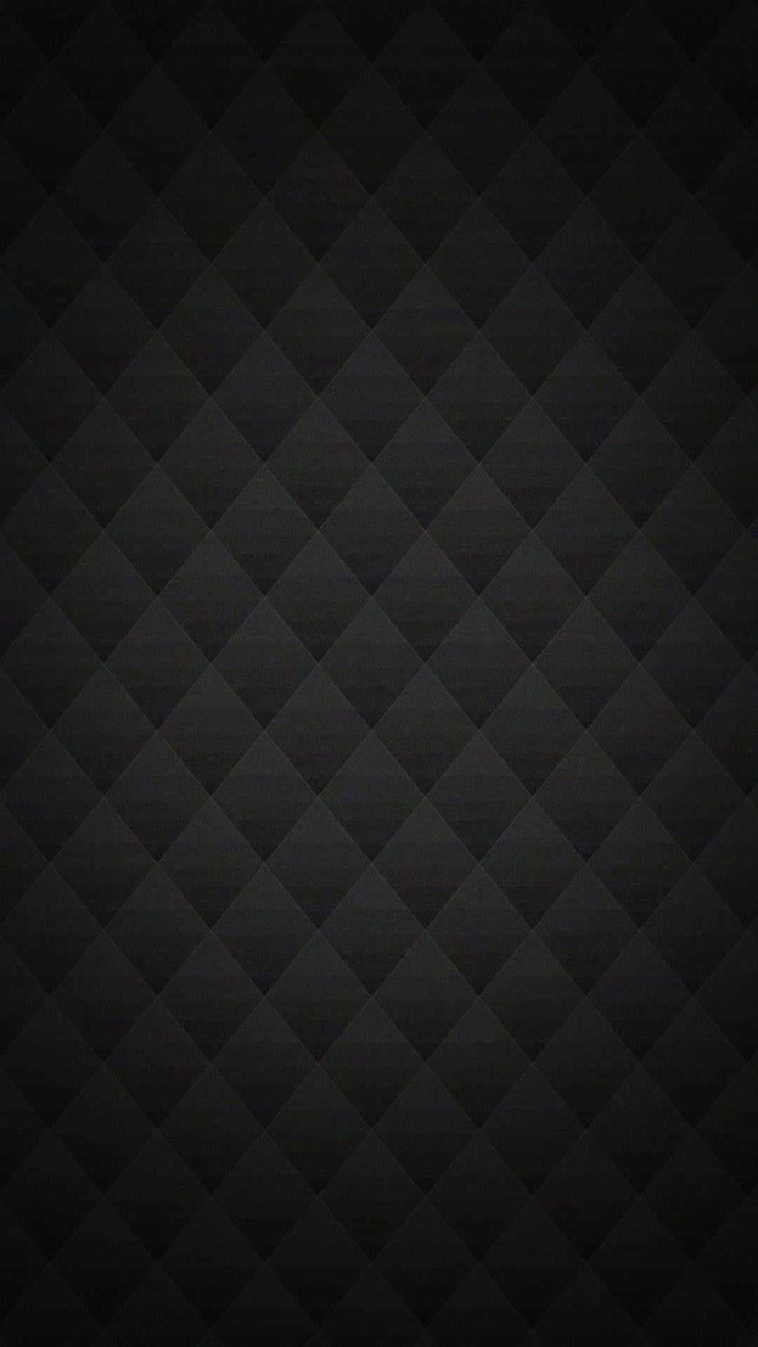 Carbon Fiber iPhone 桌布 壁紙 — 極簡黑色壁紙，帶有微妙的菱形絎縫紋理和柔和漸變燈光。