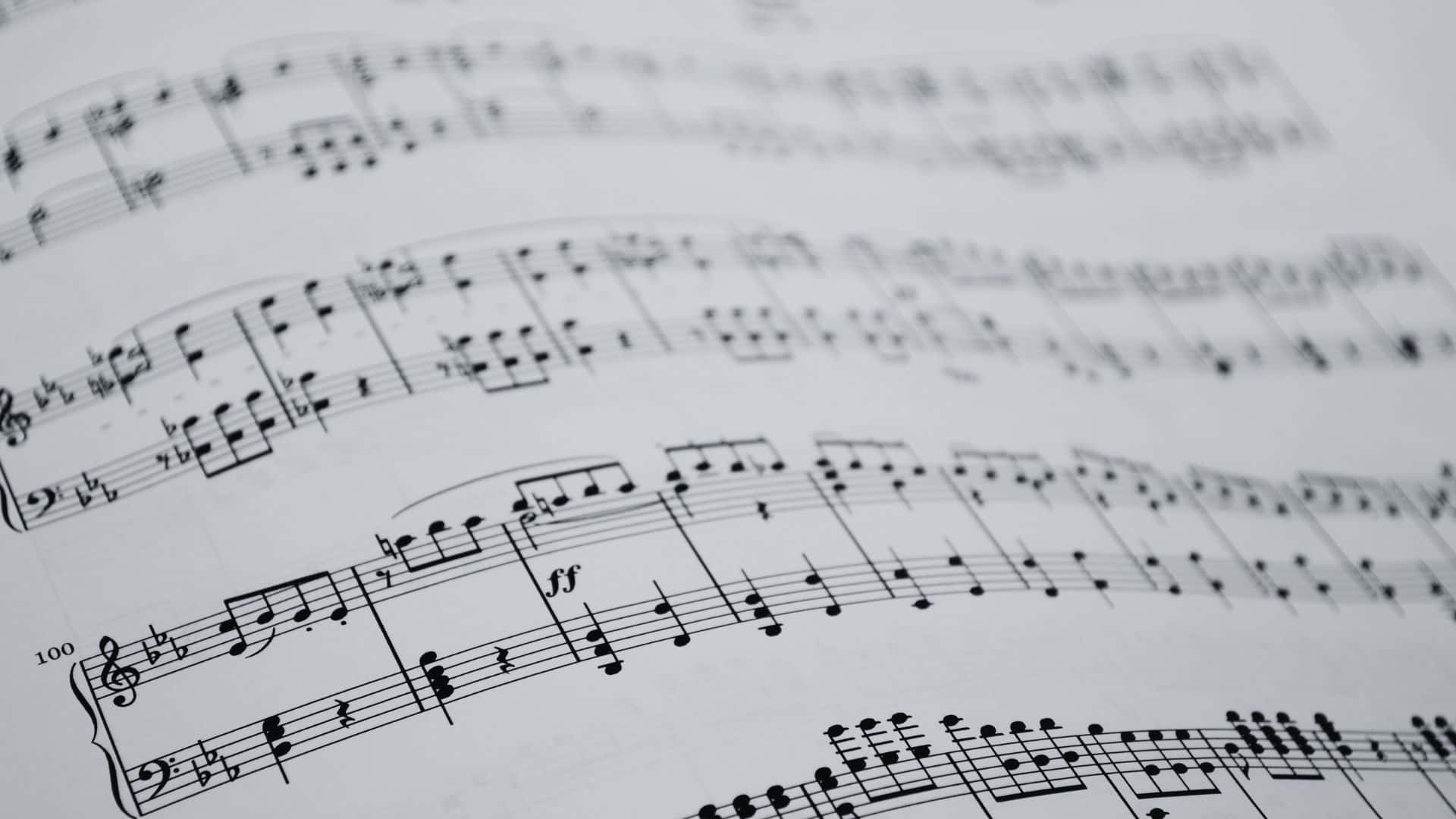 Black And White Music 桌布 壁紙 — 樂譜特寫，清晰對焦於標記為100的小節，顯示白紙上複雜的黑色音符。