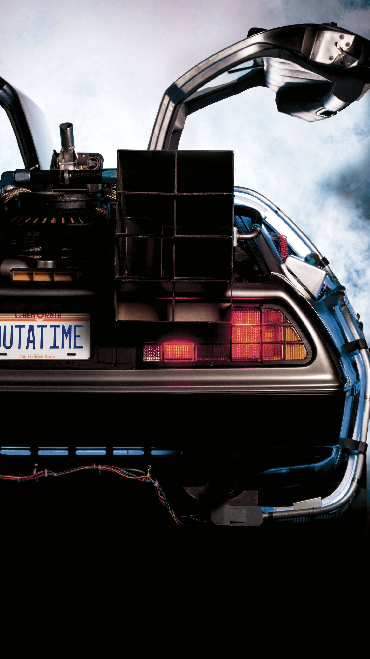Future 桌布 壁紙 — 標誌性 DeLorean 時光機的後視圖，鷗翼門打開，背景是陰天。
