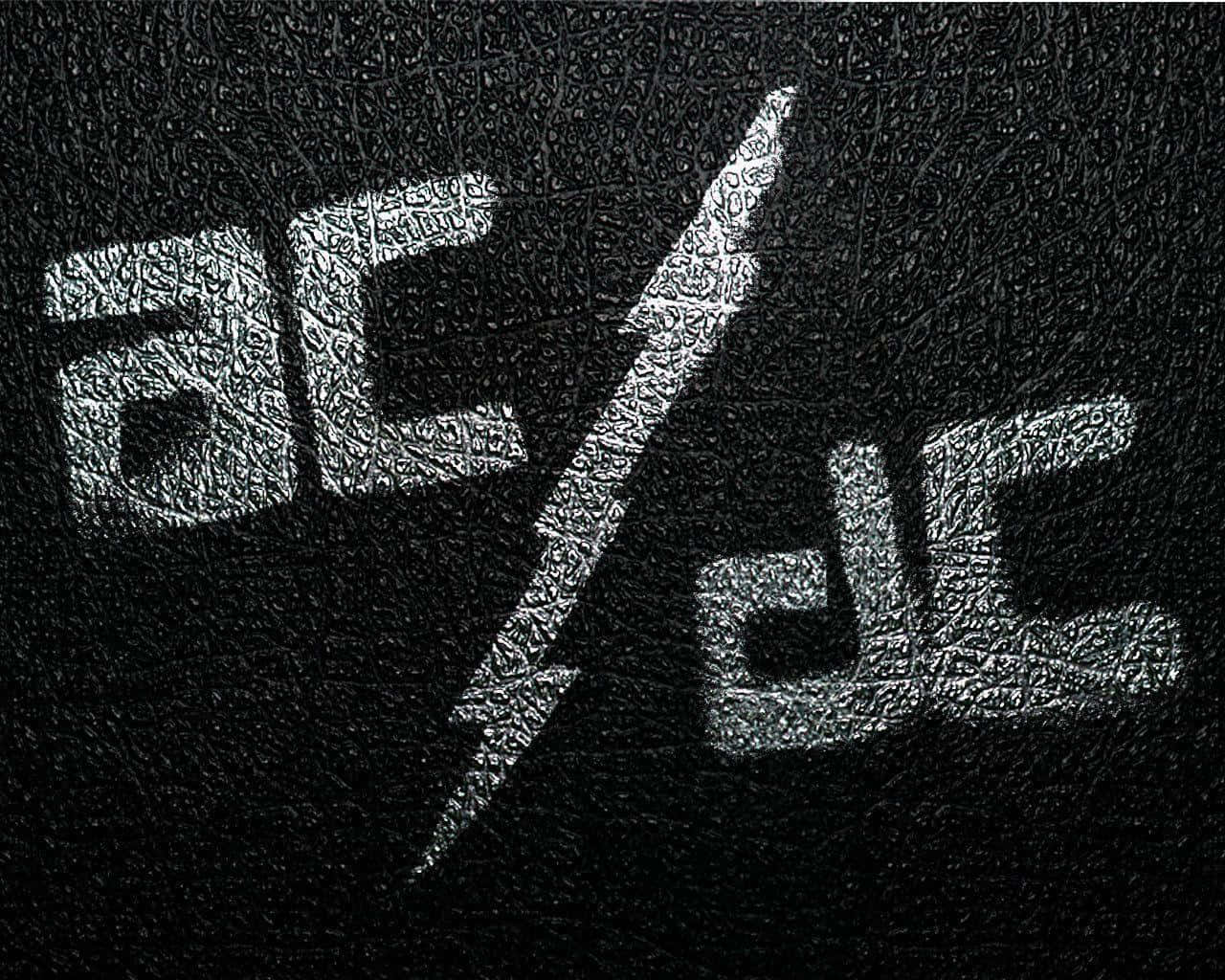 Ac Dc 桌布 壁紙 — 標誌性的AC/DC標誌以銀色蝕刻在黑色皮革上，帶有粗糙紋理表面。