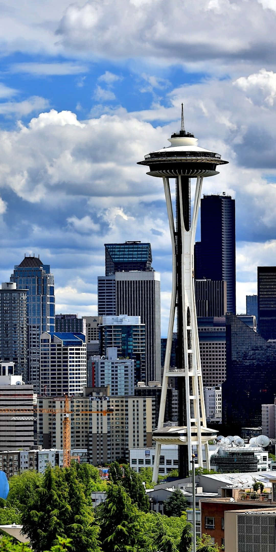 Pixel 3 Seattle 桌布 壁紙 — 標誌性的太空針塔在西雅圖的天際線上高聳入雲，背景是戲劇性的藍天，佈滿蓬鬆的白雲。