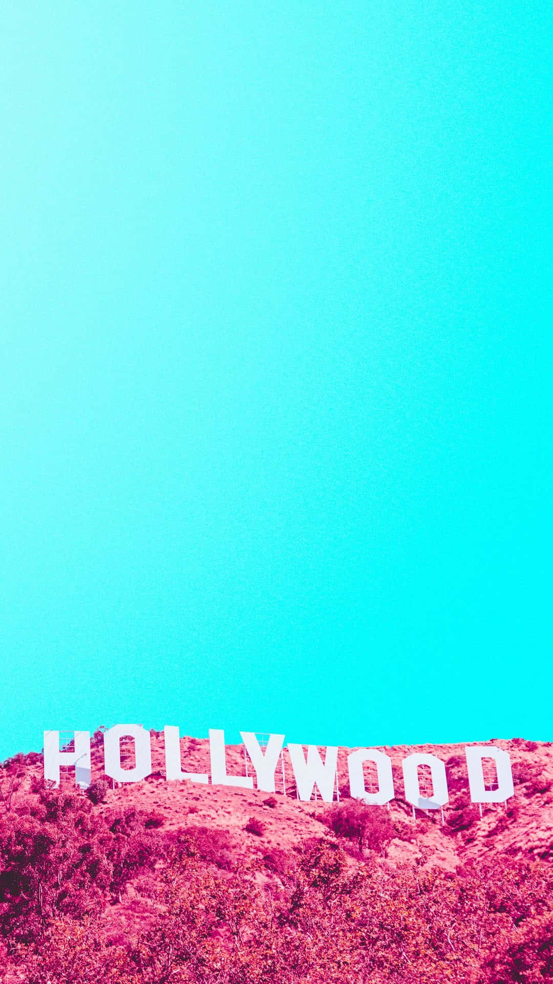 Blue Sky 桌布 壁紙 — 標誌性的好萊塢標誌在洋紅色調的山丘上，以鮮豔的青色天空為背景，傲然矗立。