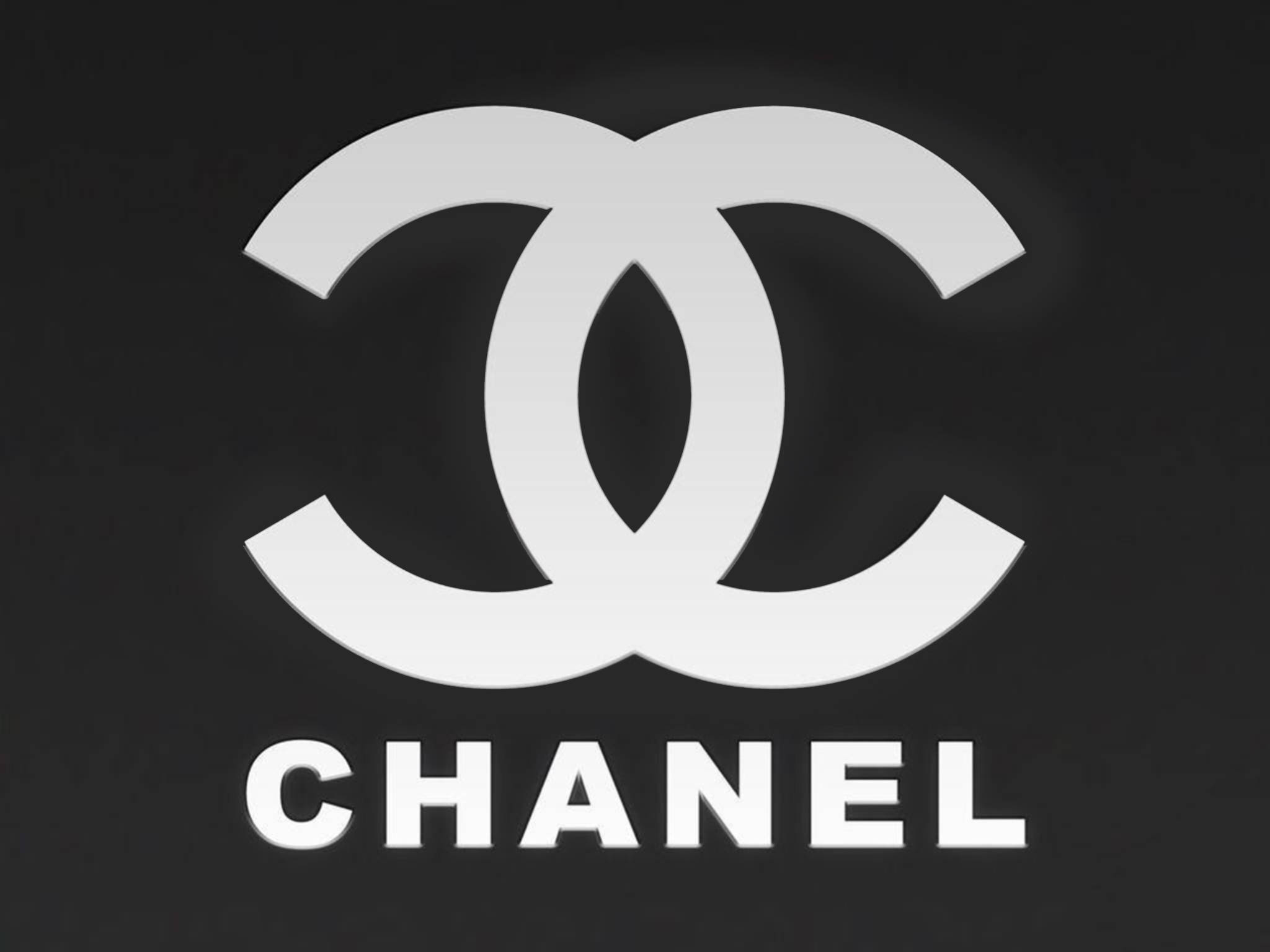 香奈兒標誌 桌布 壁紙 — 標誌性的白色Chanel標誌，帶有交織的C和品牌名稱，在純黑色背景上格外突出。