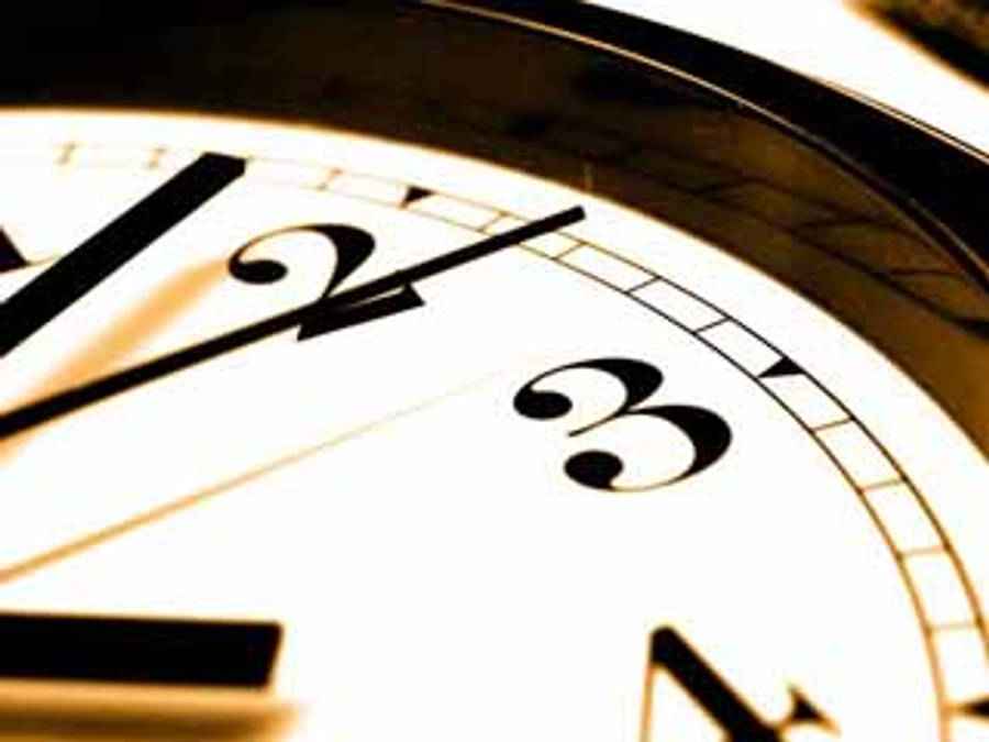 Clock 桌布 壁紙 — 模擬時鐘錶盤特寫，粗體黑色數字和指針，背景為溫暖的金色。