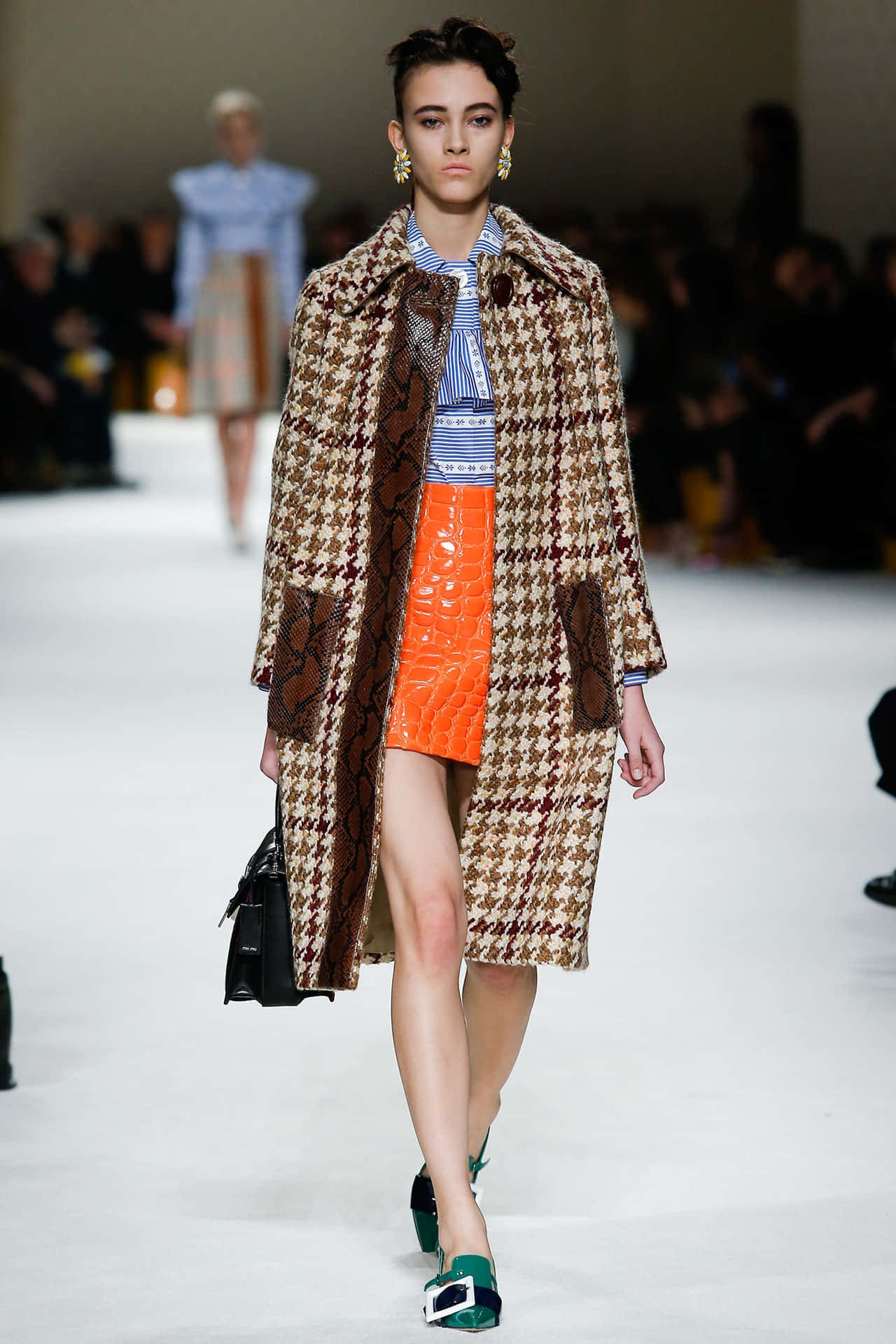 Runway 桌布 壁紙 — 模特兒身穿千鳥格大衣，搭配蛇紋貼片和亮橙色裙子走秀。