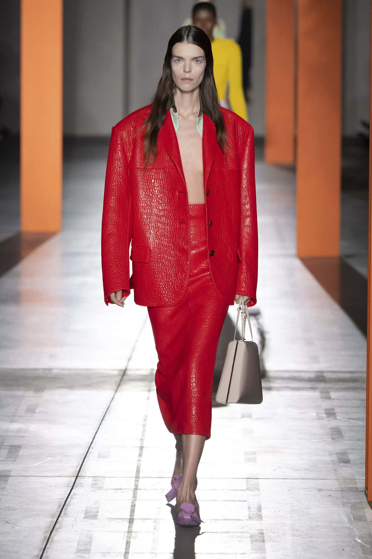 Beautiful Fashion 桌布 壁紙 — 模特兒身穿大膽的紅色紋理西裝，搭配紫色高跟鞋和米色手提包，在伸展台上走秀。