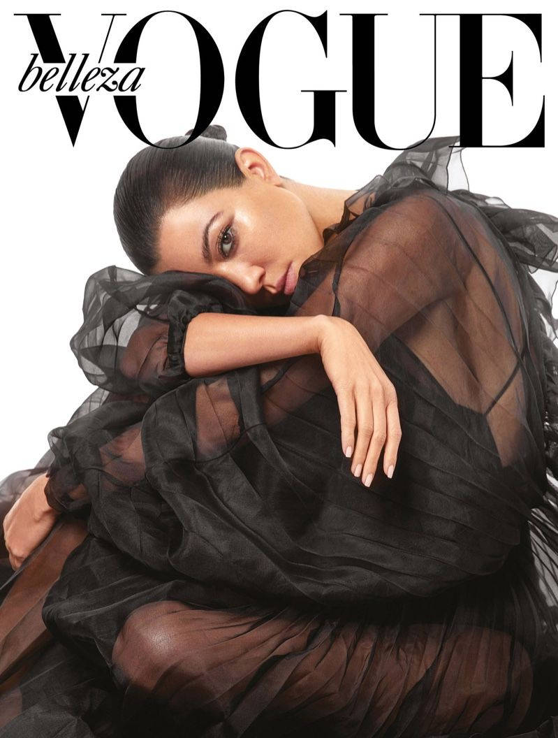 Kourtney 桌布 壁紙 — 模特兒身穿透視黑色長裙，在純白背景前親密擺姿勢，為Vogue雜誌封面拍攝。