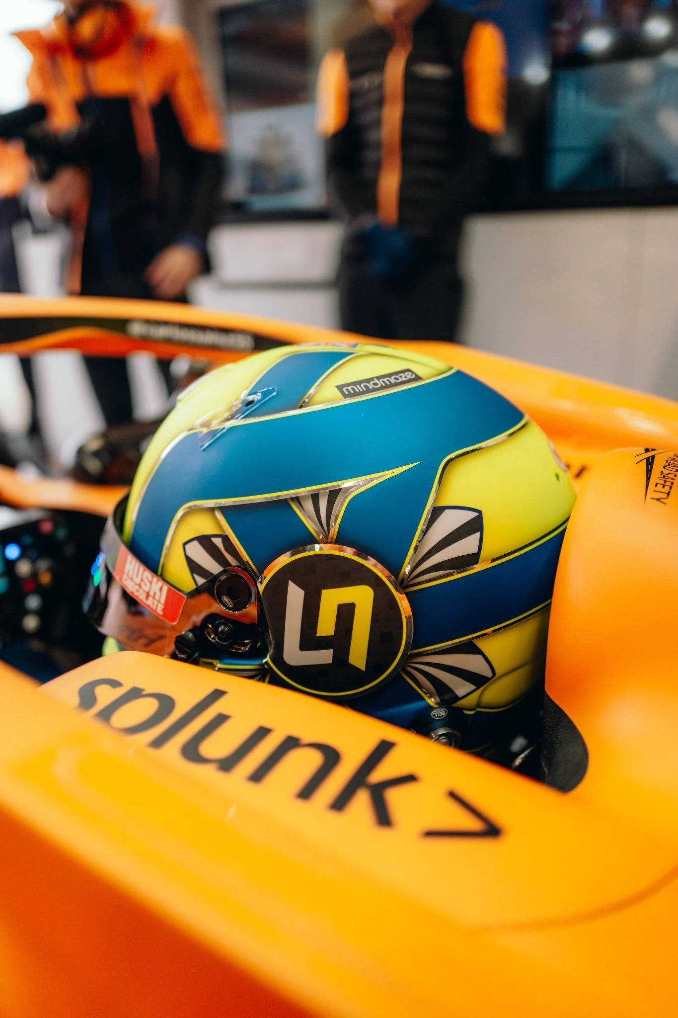 Racing 桌布 壁紙 — 橘色一級方程式賽車駕駛艙內，一個鮮豔藍黃色賽車頭盔的特寫，帶有'LN'標誌。