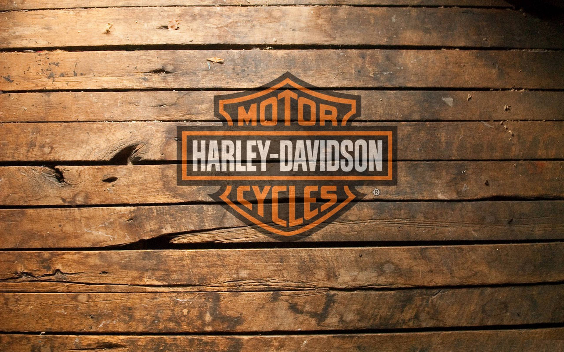 Harley 桌布 壁紙 — 橙色和黑色的Harley-Davidson標誌放置在風化的木板上，木紋和裂縫清晰可見。