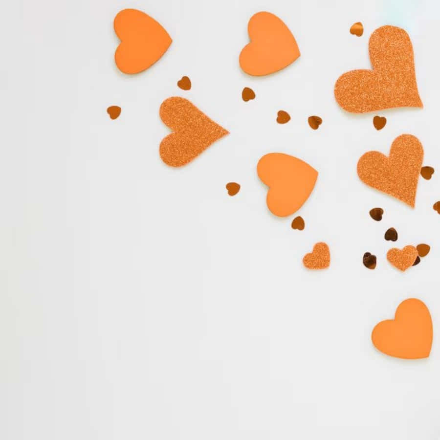 Orange Heart 桌布 壁紙 — 橙色閃粉和啞光心形對角散落在潔白表面上，營造出節日浪漫氛圍。
