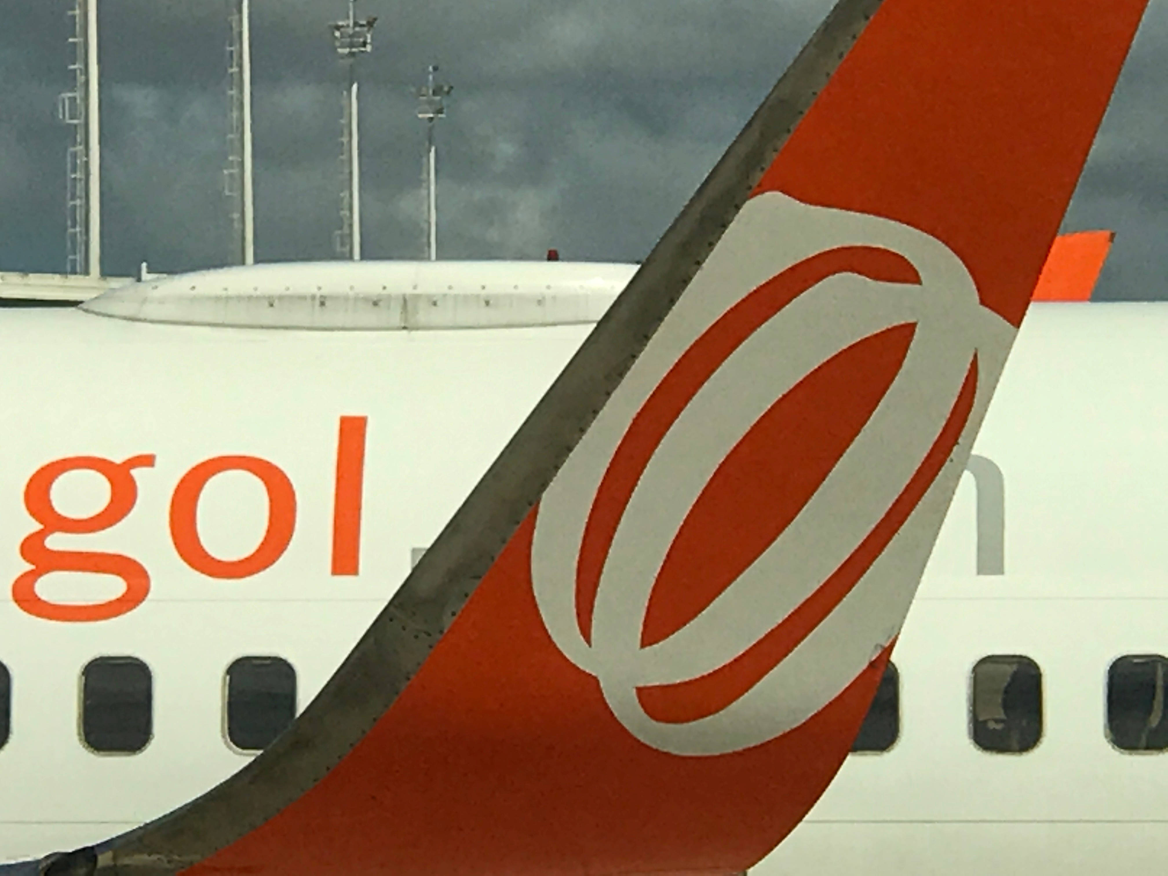 Airport 桌布 壁紙 — 機場多雲天空下，戈爾航空飛機尾部特寫，帶有醒目的橙色標誌。