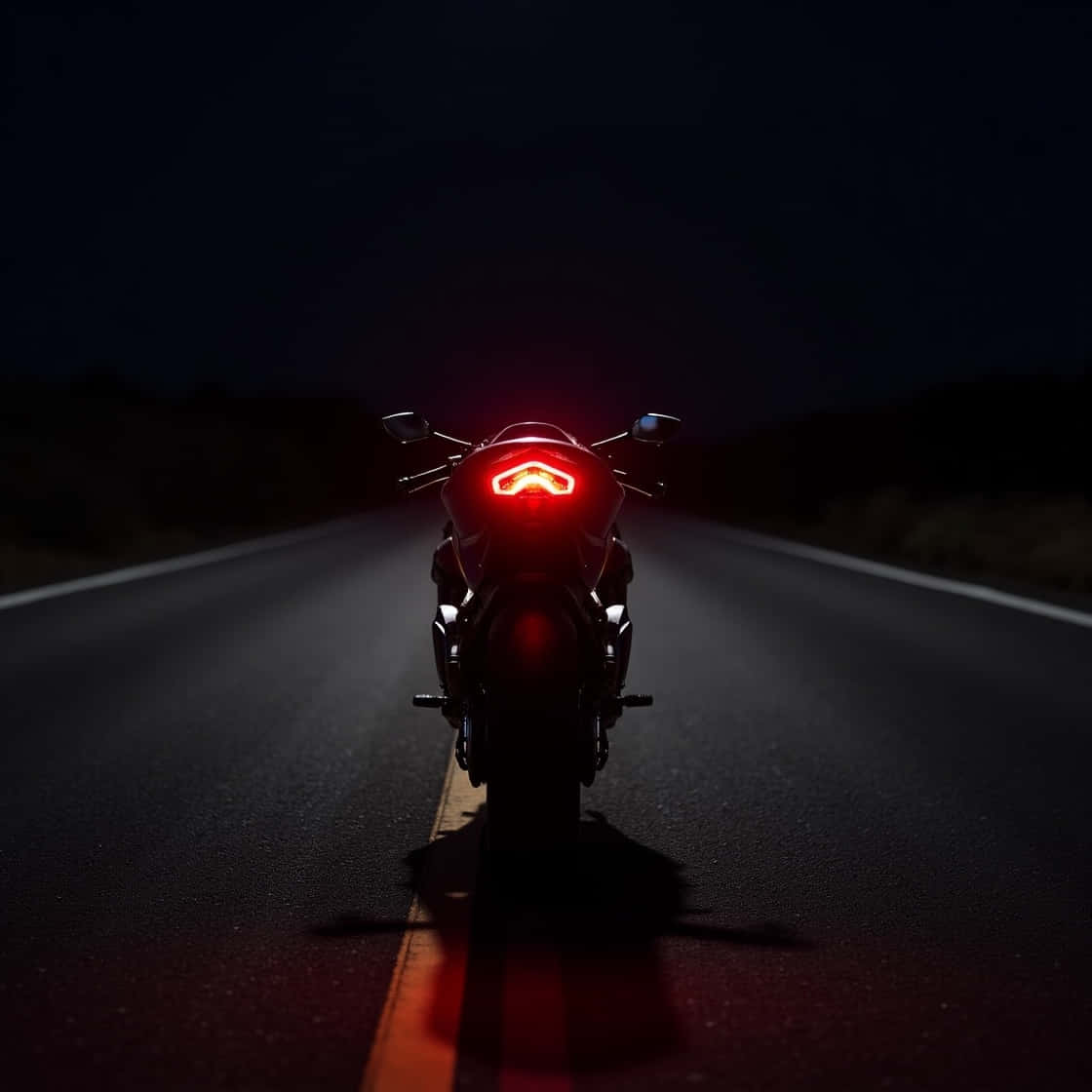 ducati panigale 壁紙 — 機車的紅色尾燈照亮了前方的黑暗道路，它停在夜間的柏油路中央。