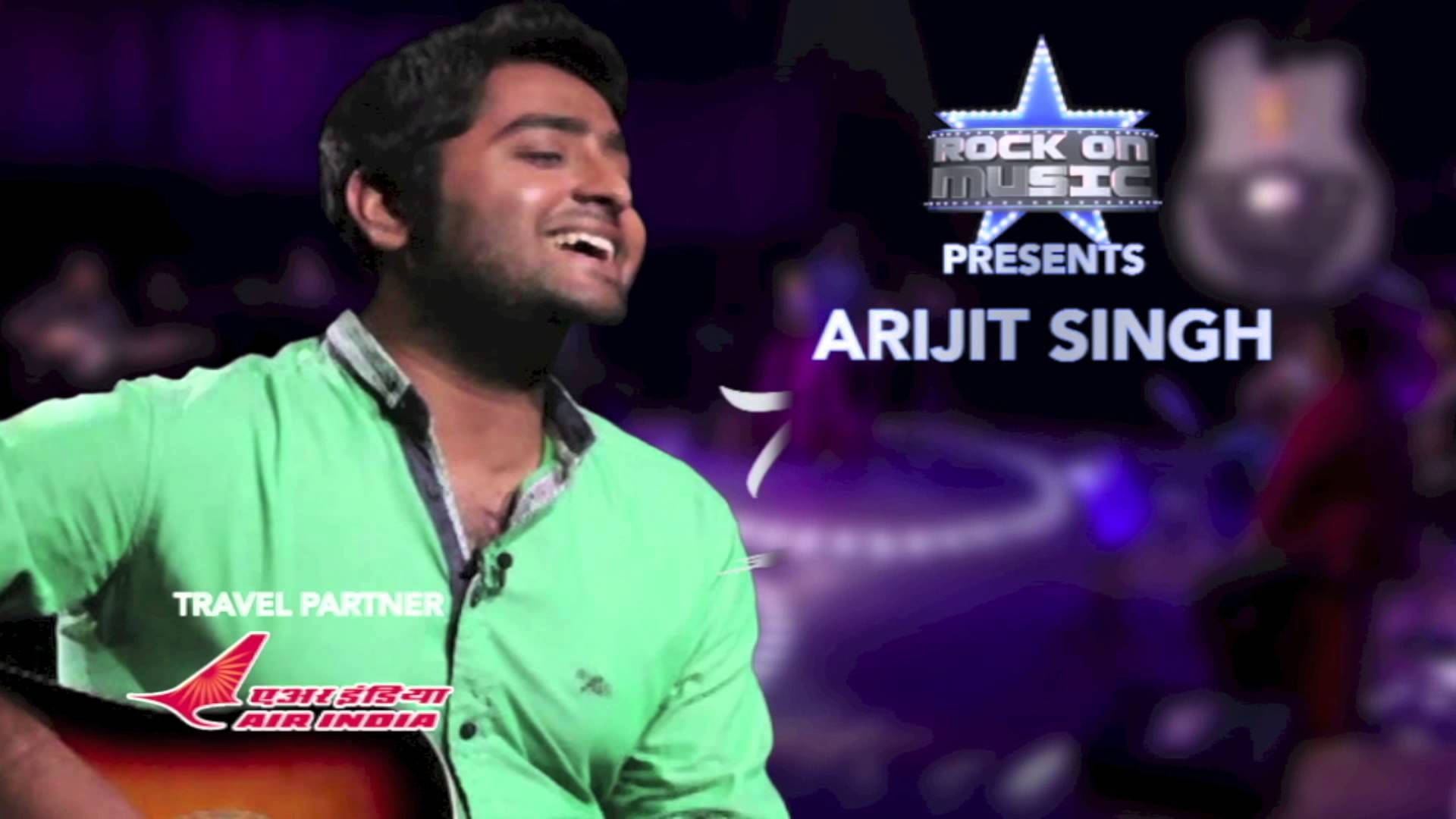 Indian 桌布 壁紙 — 歌手Arijit Singh在紫色燈光的舞台上微笑彈吉他，帶有「Rock On Music」品牌標誌。