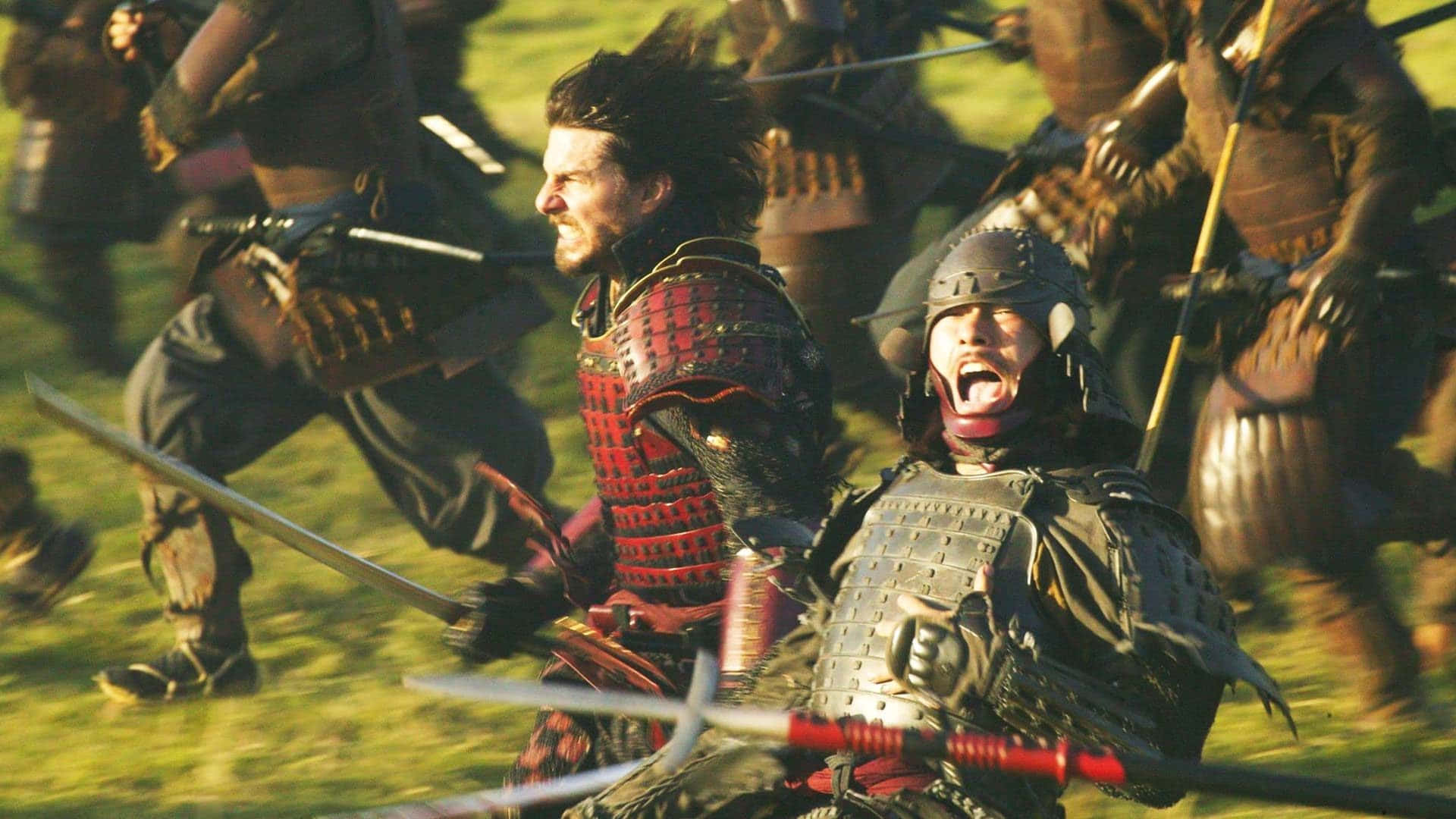 Samurai Movies 桌布 壁紙 — 武士武士在混亂的中世紀戰場上衝突，拔出劍，表情激烈，在金色陽光下。