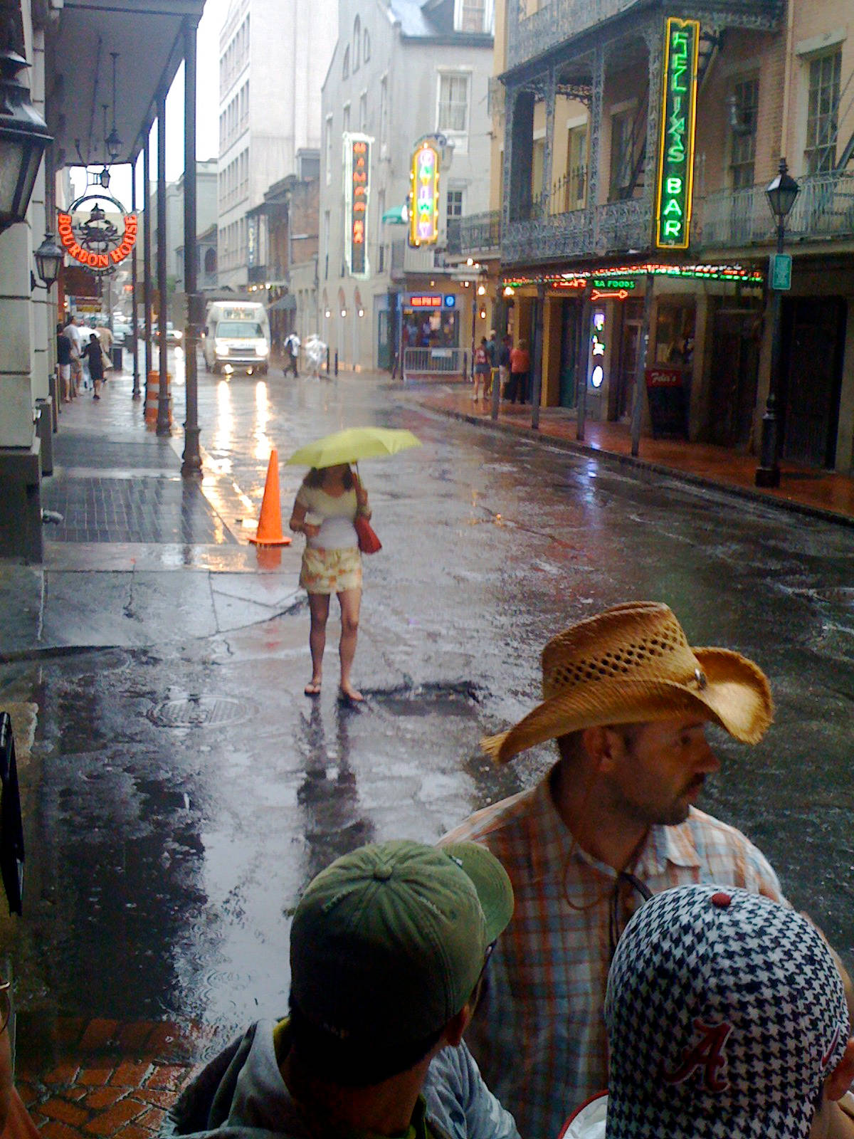 Raining 桌布 壁紙 — 歷史區的雨景街道，霓虹招牌在濕漉漉的人行道上反射，行人冒雨前行。