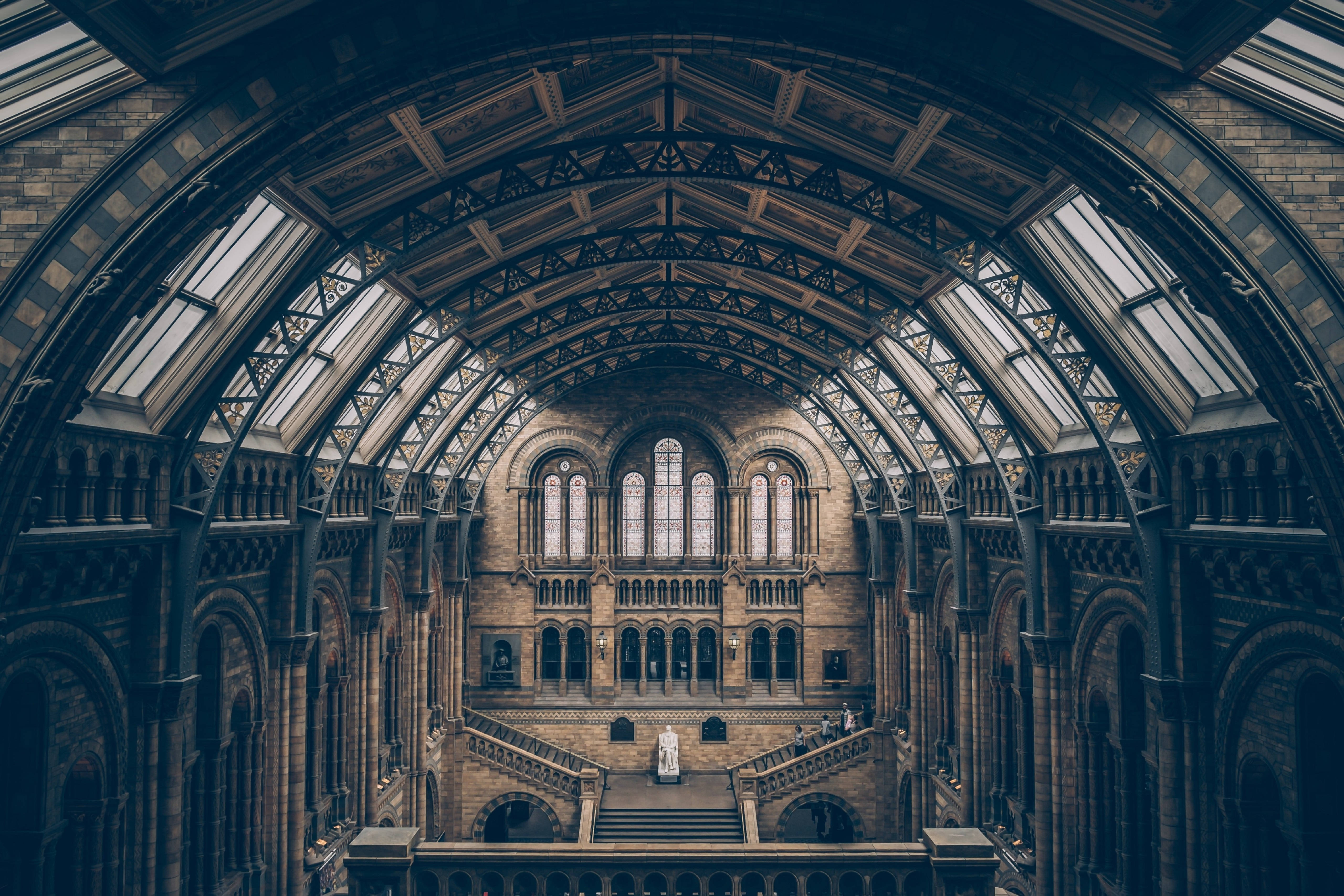 Architecture 桌布 壁紙 — 歷史博物館的宏偉拱形內部，帶有精緻的鐵藝玻璃天花板和石樓梯。