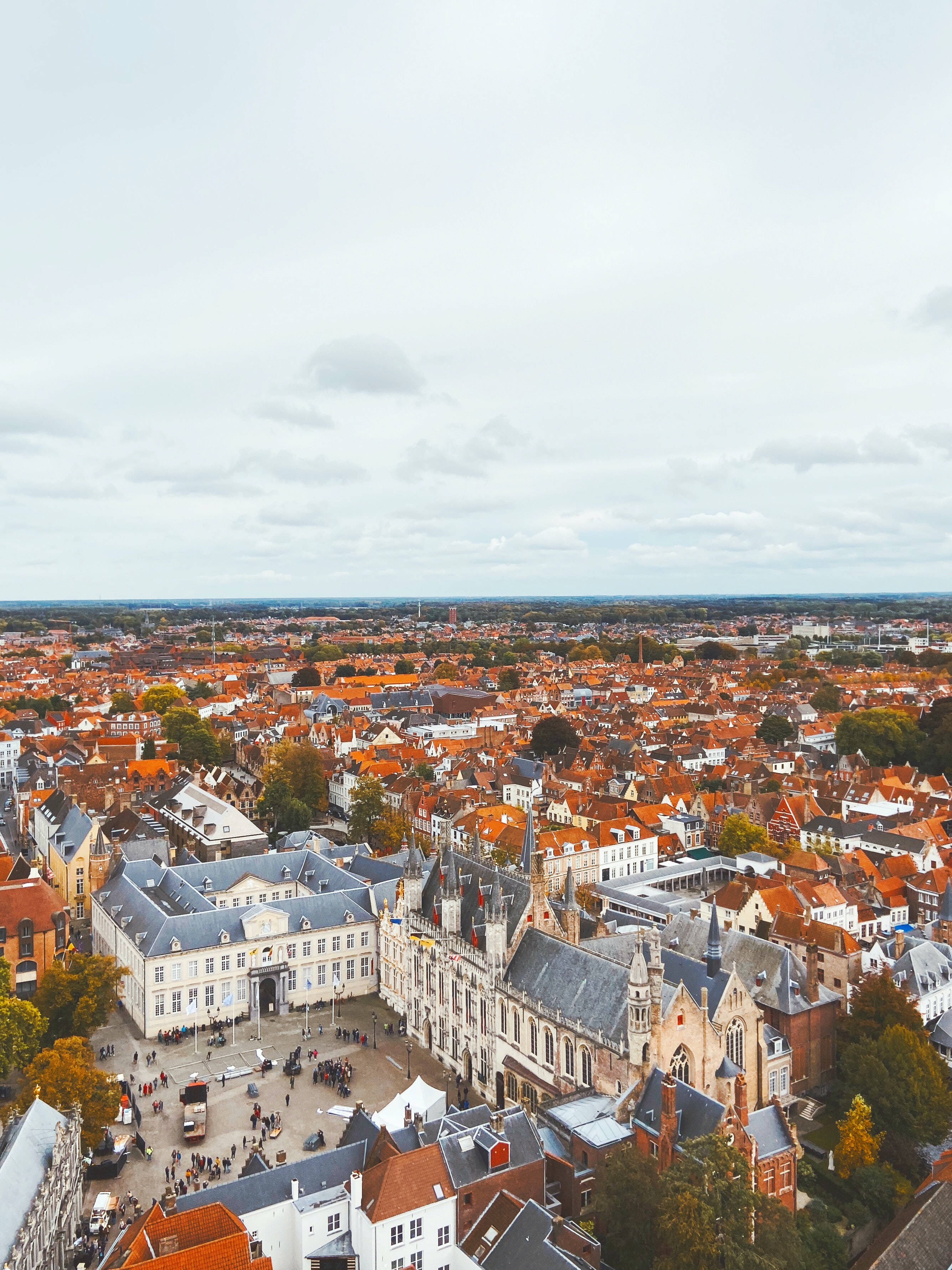 Belgium 桌布 壁紙 — 歷史悠久的歐洲城市鳥瞰圖，擁有紅色瓦片屋頂和哥德式建築，天空多雲。