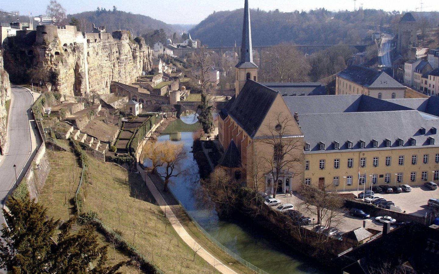Luxembourg 桌布 壁紙 — 歷史悠久的歐洲小鎮鳥瞰圖，蜿蜒的河流流經石頭建築和懸崖上的城堡。