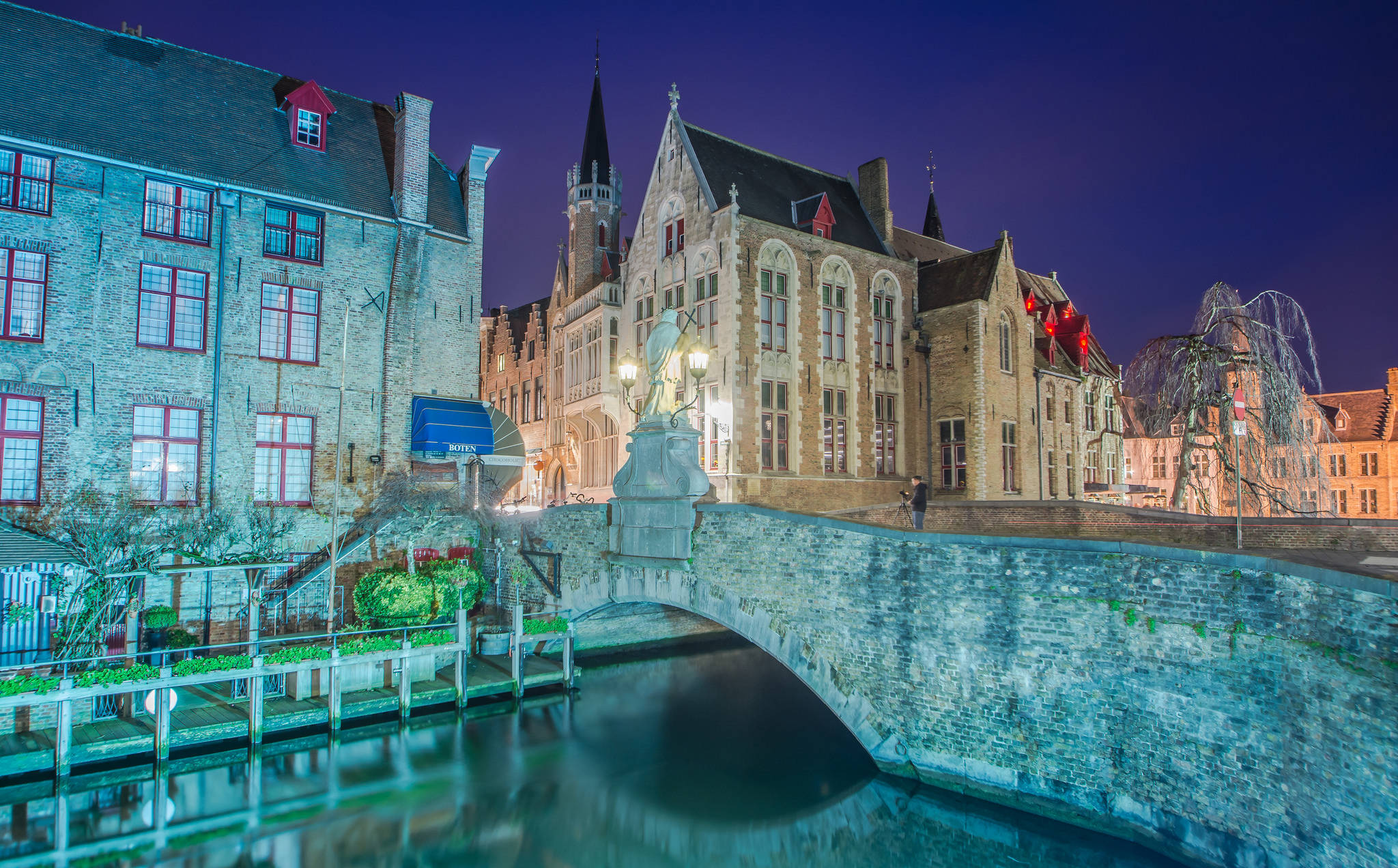 Belgium 桌布 壁紙 — 歷史悠久的歐洲運河的寧靜夜景，石橋和燈火通明的中世紀建築倒映在平靜的水面上。