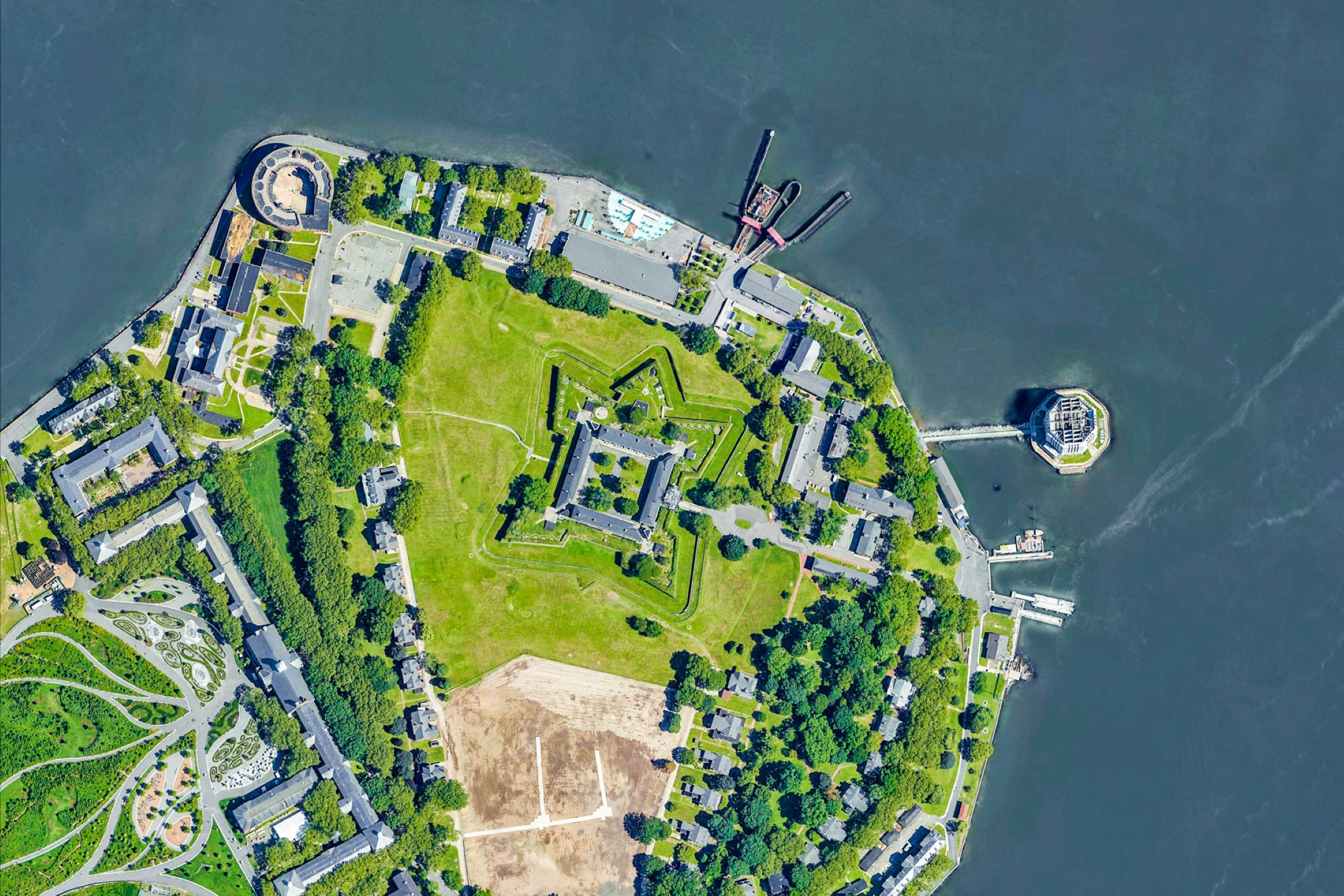 Google 地球 桌布 壁紙 — 歷史星形堡壘的鳥瞰圖，位於鬱鬱蔥蔥的綠色島嶼上，周圍環繞著平靜的藍色海水，設有碼頭和建築物。