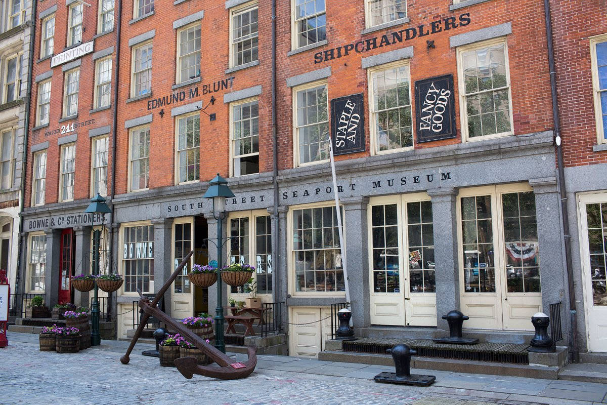 Museum 桌布 壁紙 — 歷史磚砌建築，帶有復古商店招牌和一個大錨，位於鵝卵石街道上。