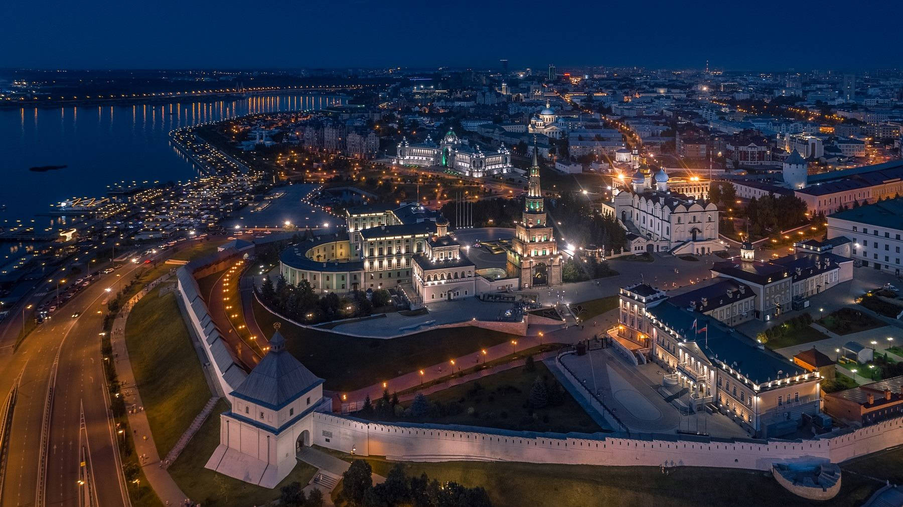 Kazan 桌布 壁紙 — 歷史要塞城市的夜間空中景觀，河流和道路沿線閃爍著燈光。