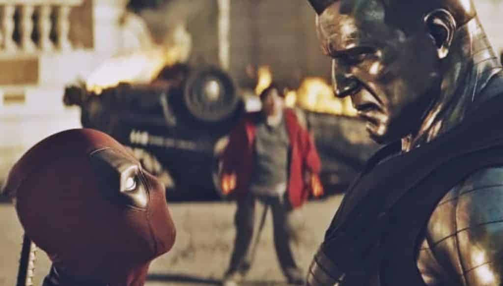 Deadpool And Colossus 桌布 壁紙 — 死侍在火熱的城市戰場上面對一個金屬皮膚的威脅性變種人，旁邊還有一個穿紅衣的旁觀者。