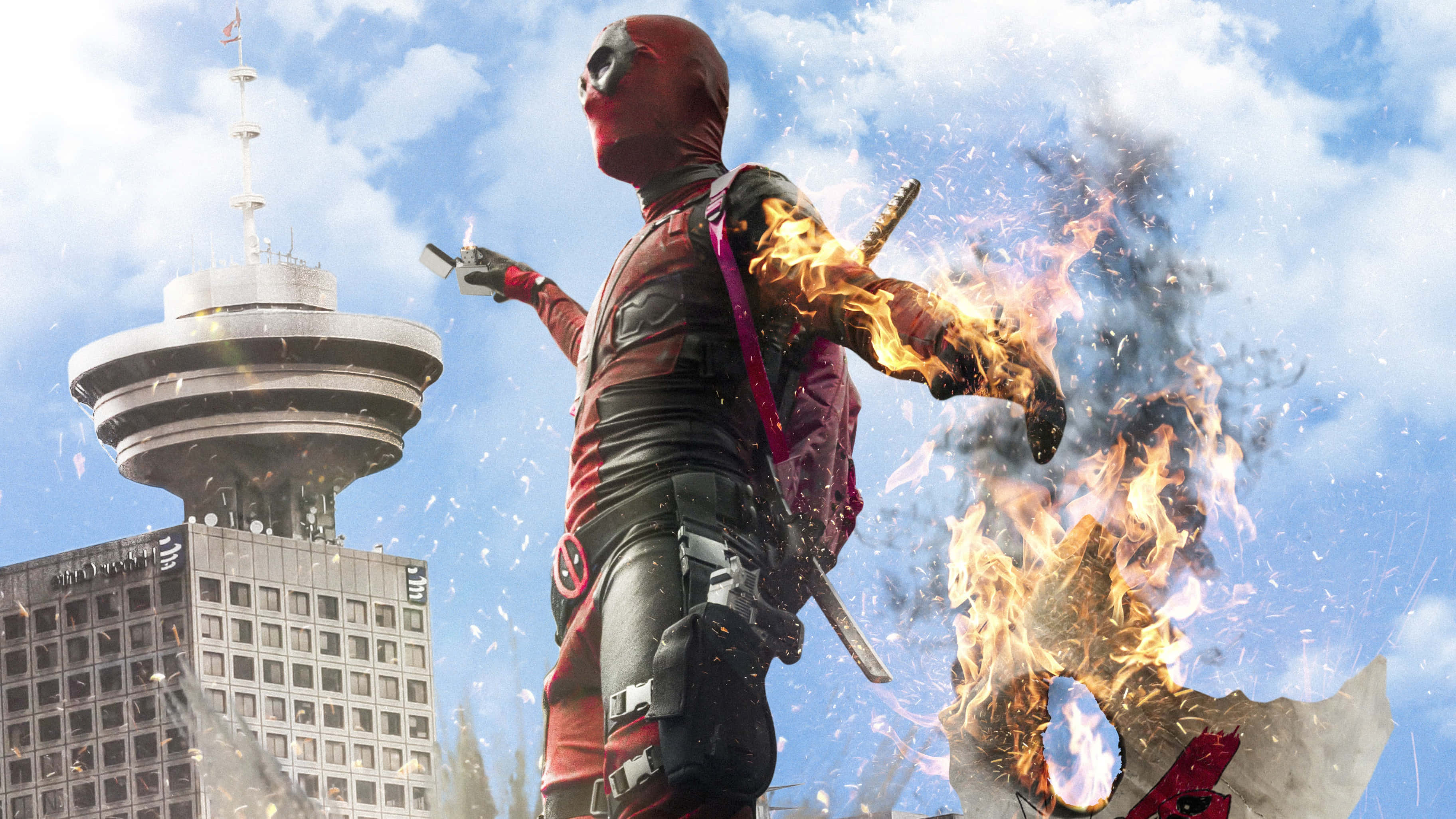 Deadpool 2 桌布 壁紙 — 死侍站在多倫多地標CN塔前，在明亮的藍天下置身於熾熱的爆炸中。