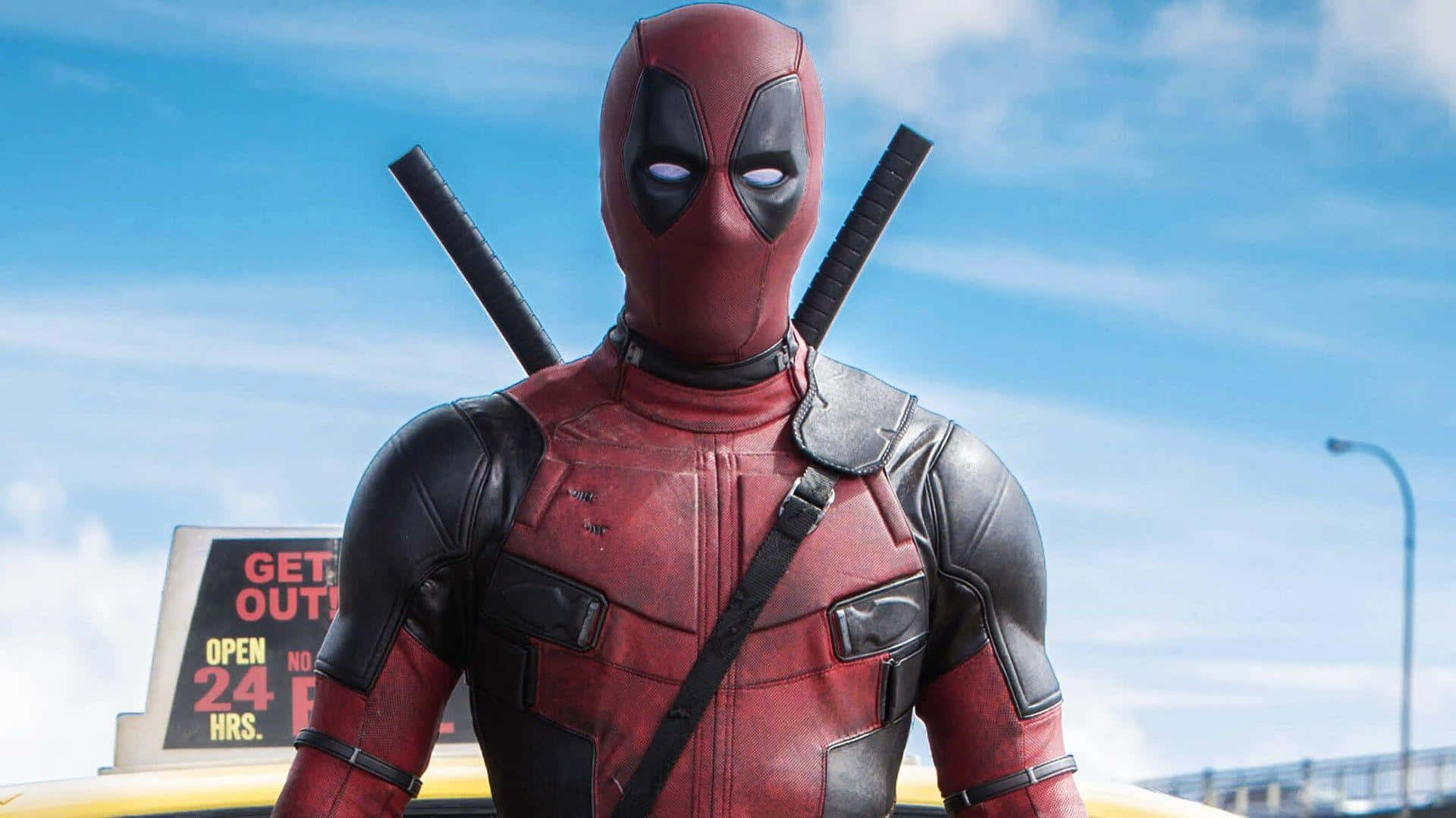 Deadpool 2 桌布 壁紙 — 死侍自信地站立，身穿紅黑戰衣，背負武士刀，背景是明亮的藍天。