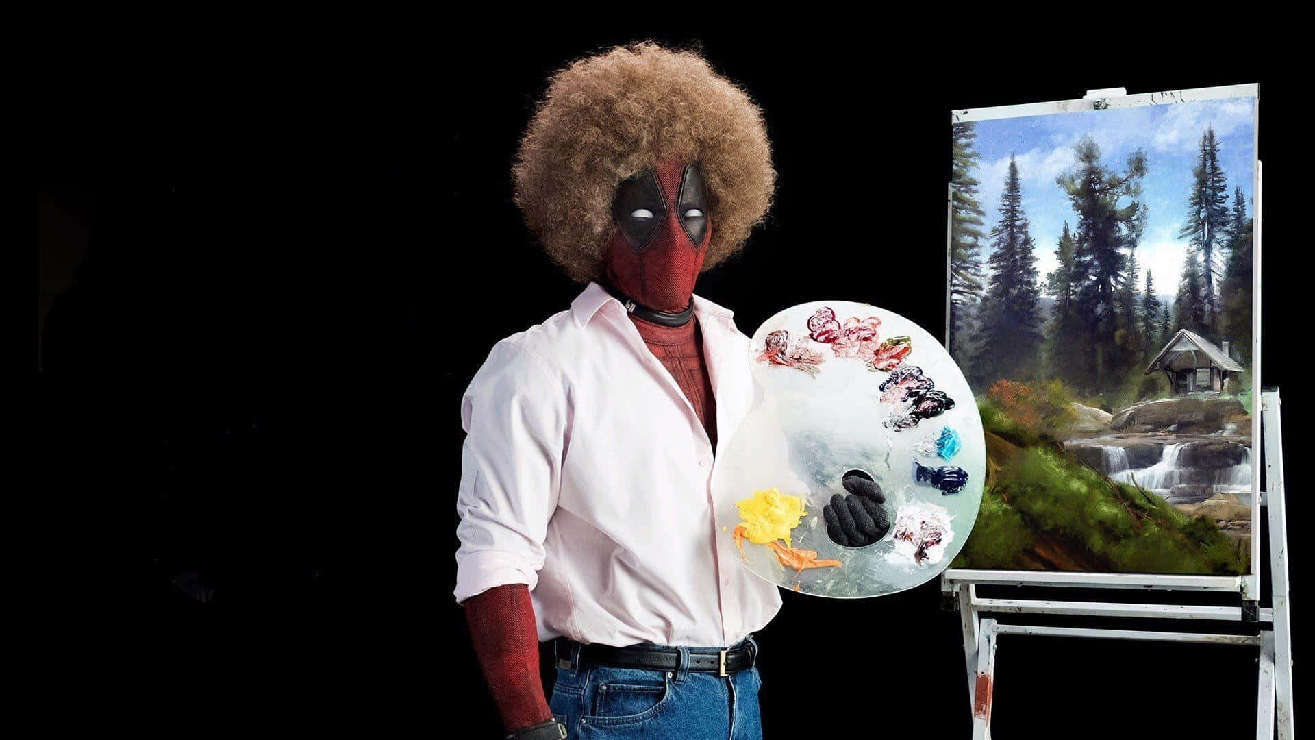 Deadpool 2 桌布 壁紙 — 死侍身穿白襯衫和牛仔褲，在畫架旁拿著調色板，畫架上展示著一幅黑色背景的森林瀑布畫。